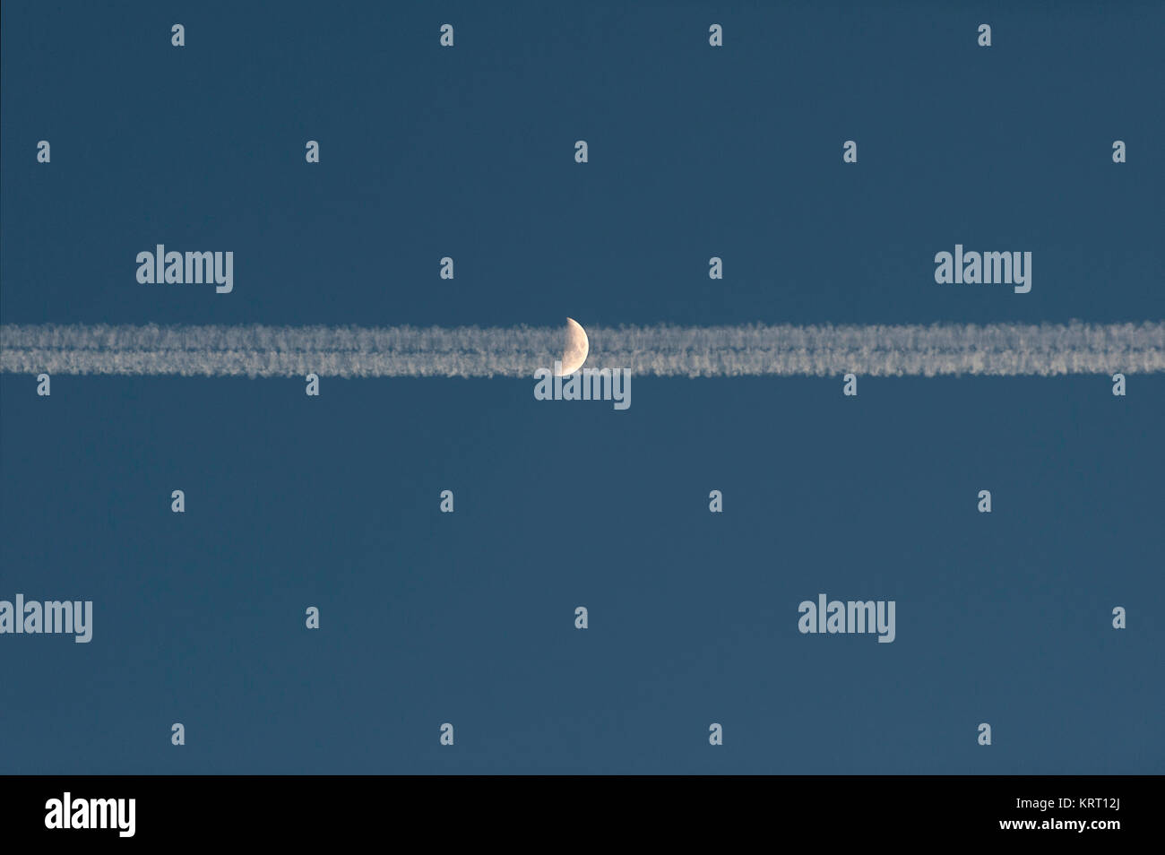 Traînées d'un avion à réaction avant le croissant.. Von Kondensstreifen Düsenflugzeugs vor dem Halbmond. Banque D'Images