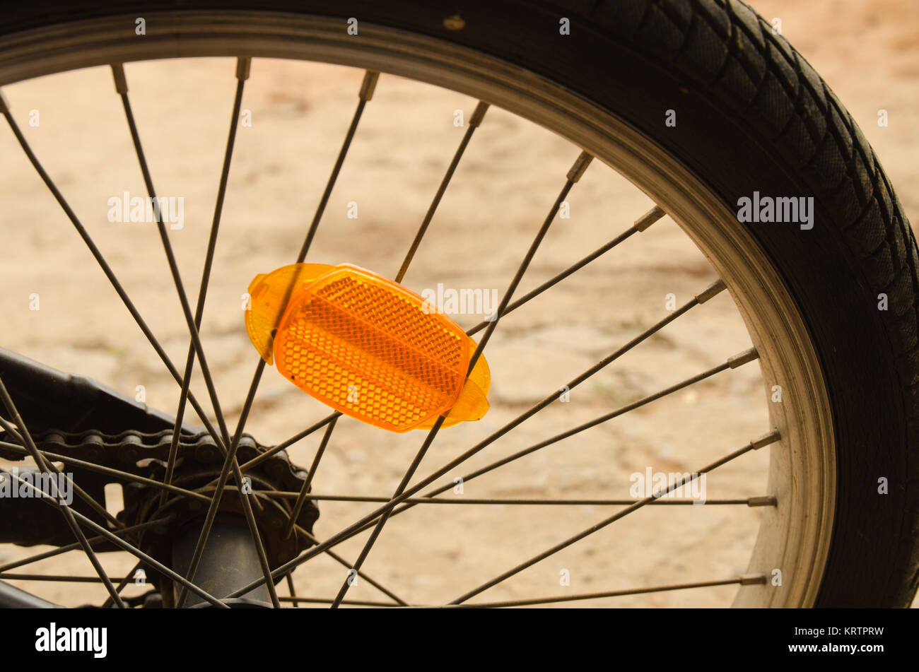 Gros plan d'une roue de bicyclette montrant le réflecteur orange et rayons Banque D'Images