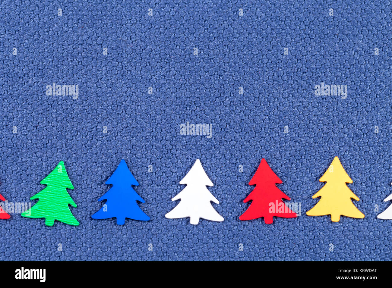 Carte de Noël avec des arbres de Noël sur fond de tissu bleu Banque D'Images