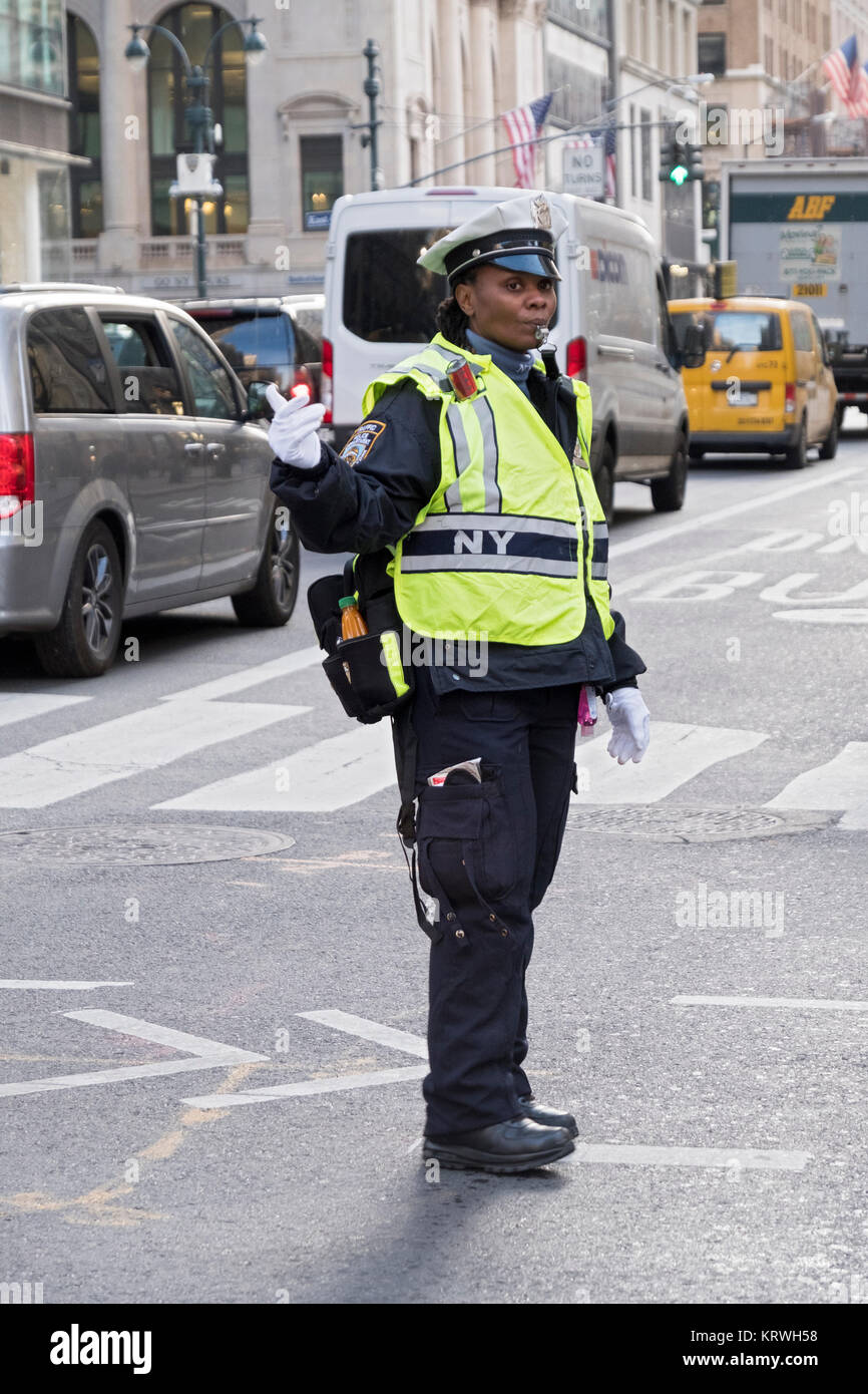 Une policière de diriger la circulation sur la 5e Avenue et 43e Rue à Midtown Manhattan, New York. Banque D'Images