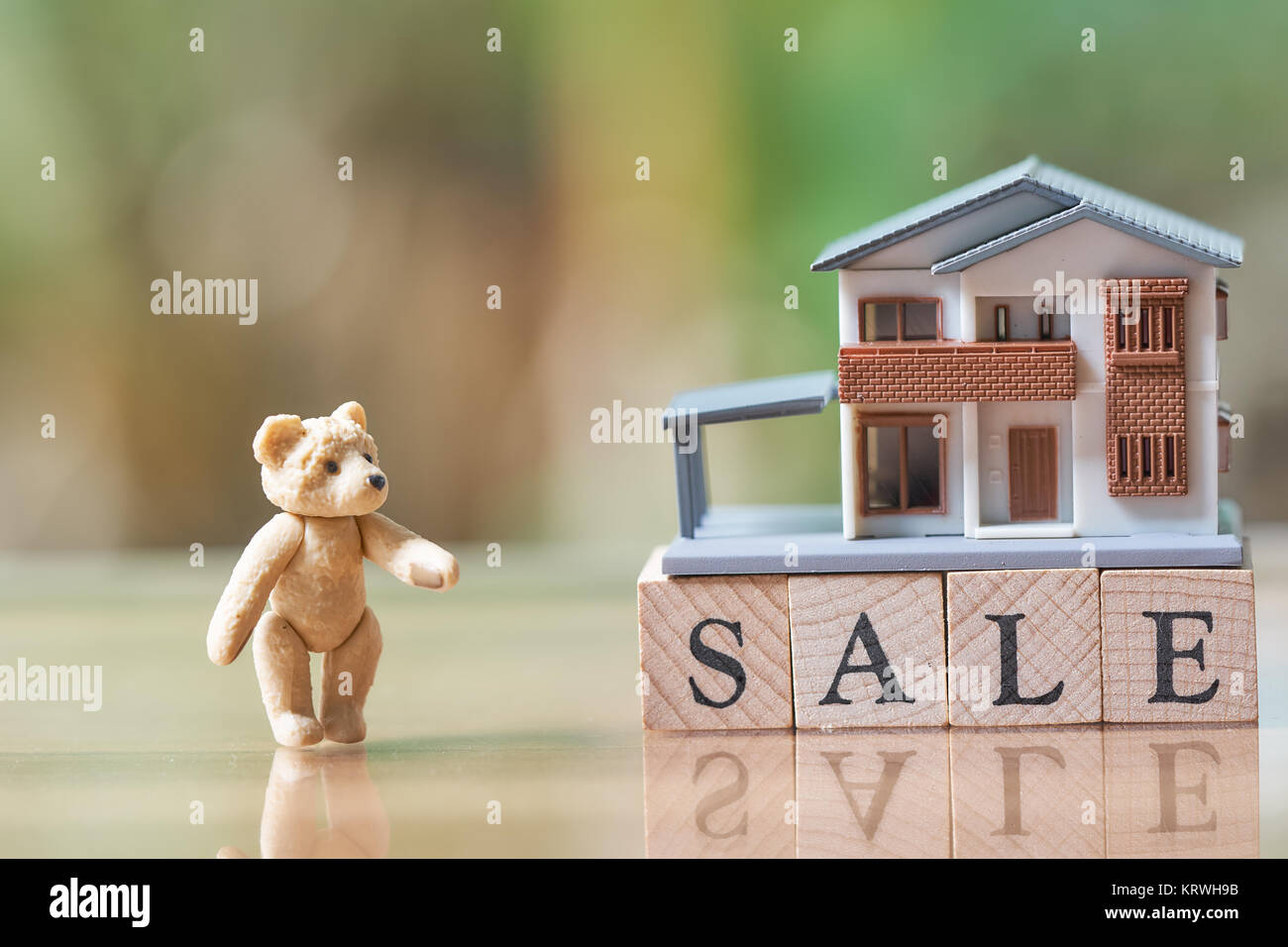 Un modèle de maison modèle et ours est placé sur bois vente Mot.en tant que concept et business real estate concept avec copie espace. Banque D'Images