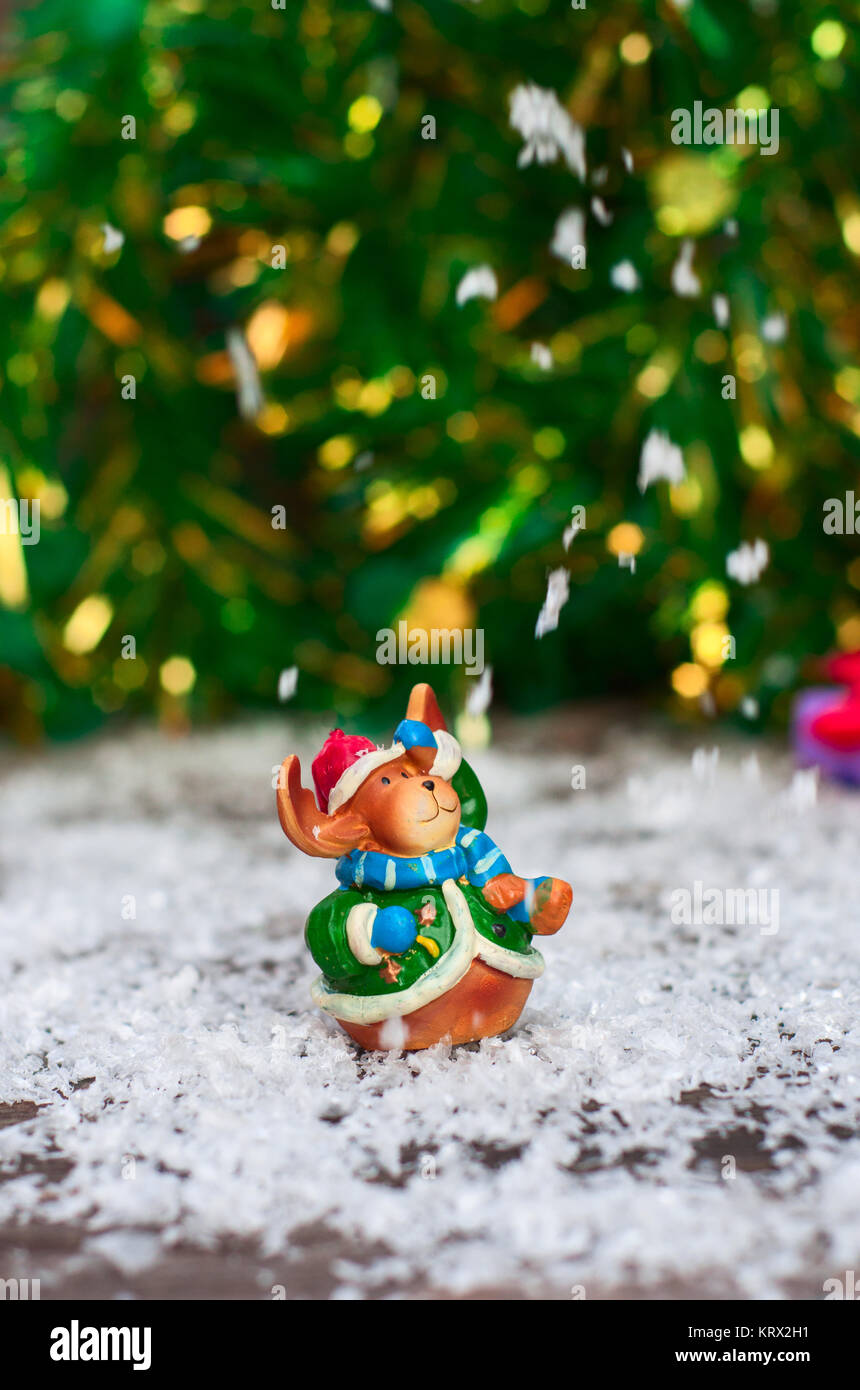 Jouets de Noël en céramique elk en vêtements de fête debout dans la neige Banque D'Images