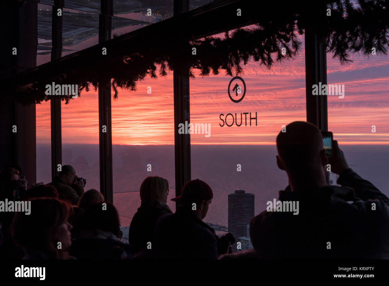 Chicago, USA. 21 décembre 2017. Météo. Les membres du public se rassemblent pour regarder le lever du soleil à partir de la chambre 360 Chicago, une plate-forme d'observation populaire sur la 94e étage de la John Hancock Building skyscraper. Le lever du soleil marque deux premier jour de l'hiver sur le solstice d'astronomie sur le jour le plus court de l'année. Crédit : Stephen Chung / Alamy Live News Banque D'Images