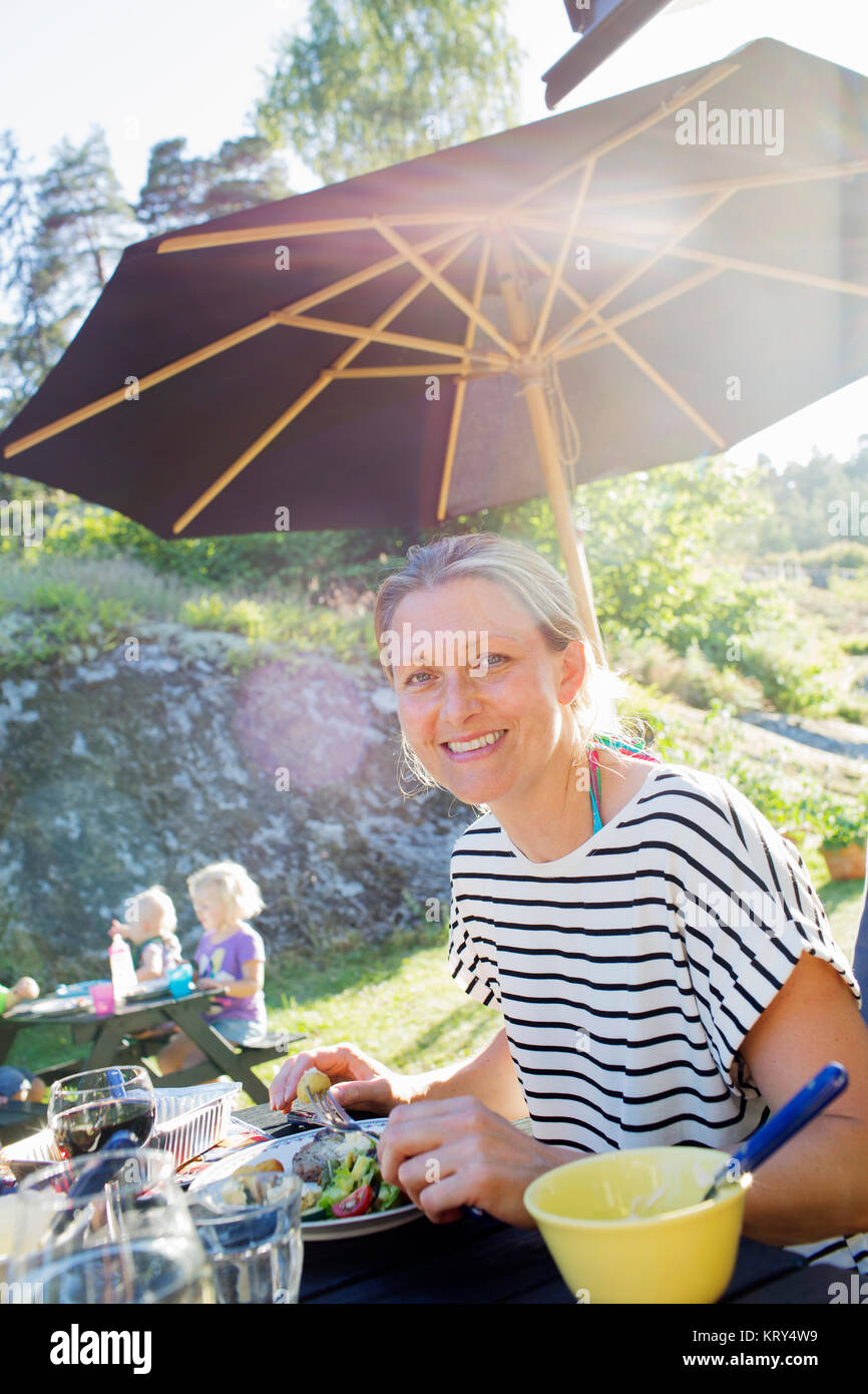 A smiling woman eating outdoors Banque D'Images