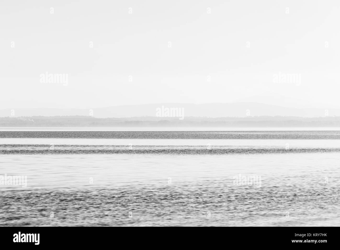 Vue graphique minimaliste de lac Trasimeno (Ombrie), avec bandes de teintes différentes et un ciel vide totalement Banque D'Images