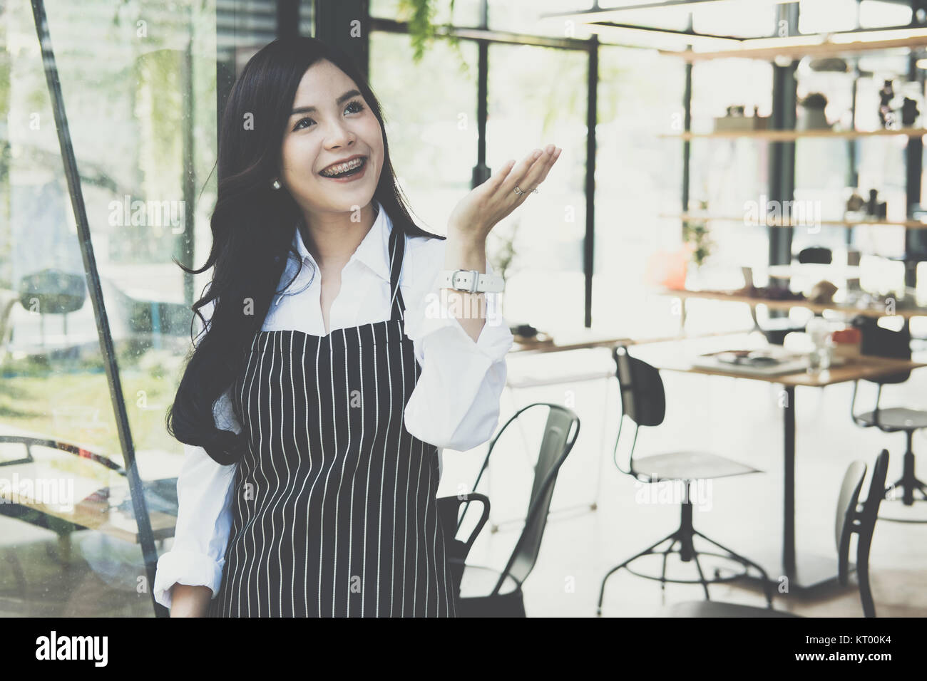 Small business owner standing at coffee shop. asian female barista portant un tablier smiling at cafe. food service, concept de restaurant. Banque D'Images