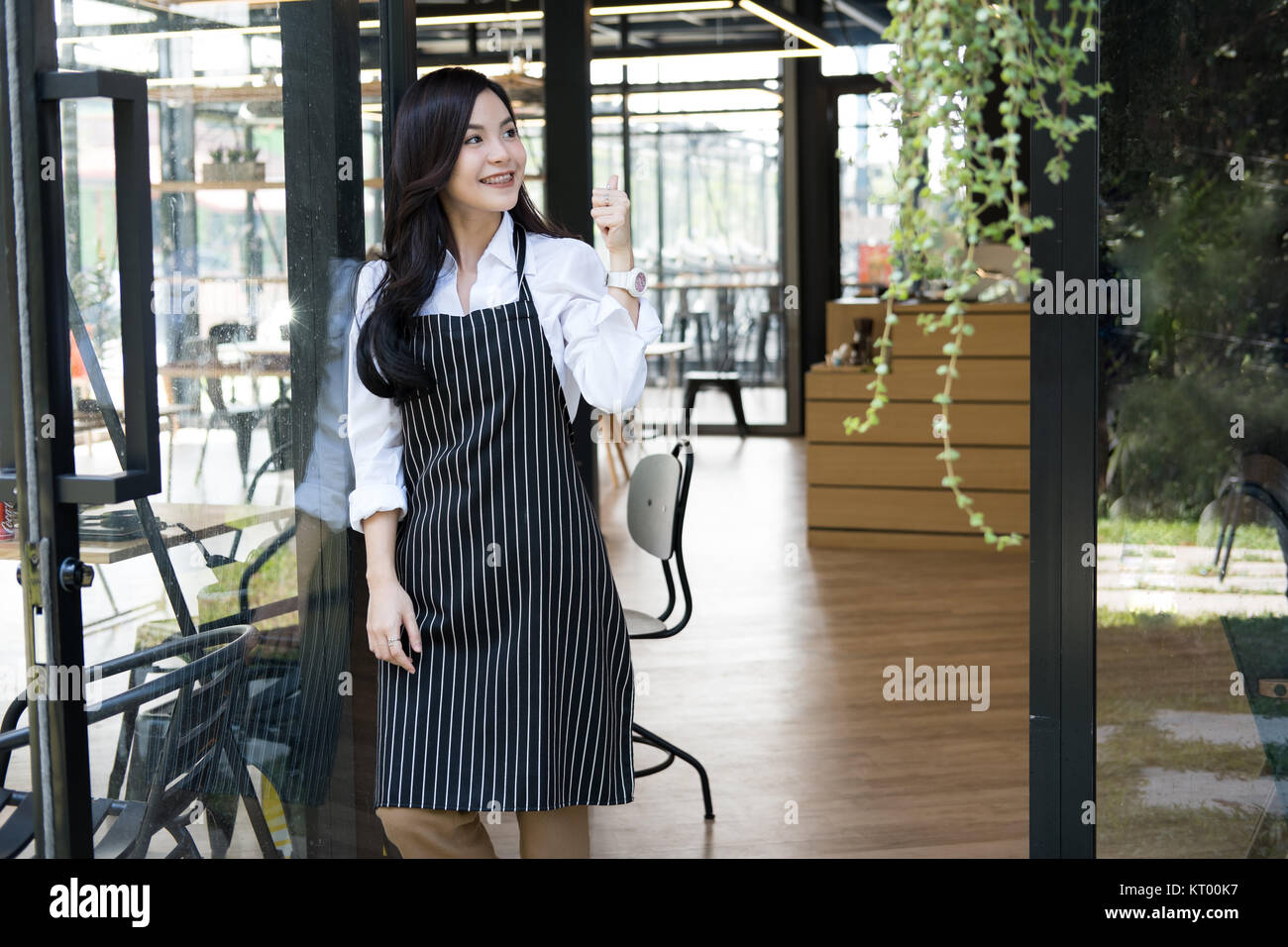 Small business owner standing at coffee shop. asian female barista portant un tablier smiling at cafe. food service, concept de restaurant. Banque D'Images