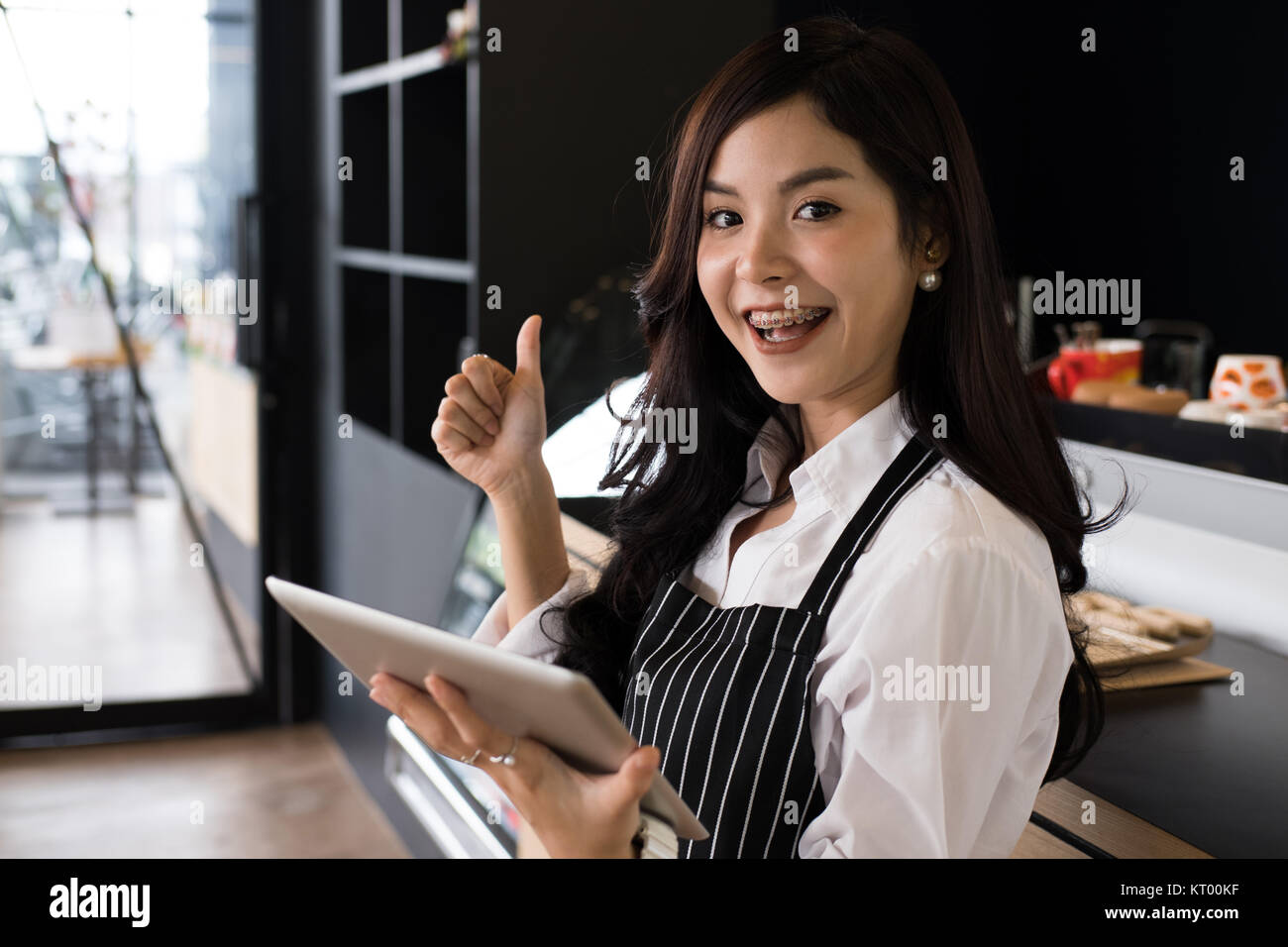 Propriétaire de petite entreprise holding tablet in coffee shop. asian female barista de porter un tablier à l'aide au touchpad dans bar cafe. service alimentaire, restaur Banque D'Images
