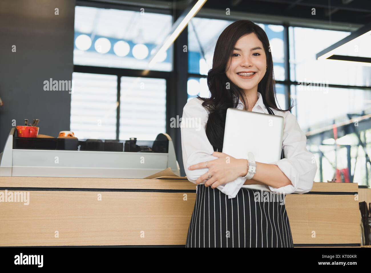Propriétaire de petite entreprise holding tablet in coffee shop. asian female barista de porter un tablier à l'aide au touchpad dans bar cafe. service alimentaire, restaur Banque D'Images
