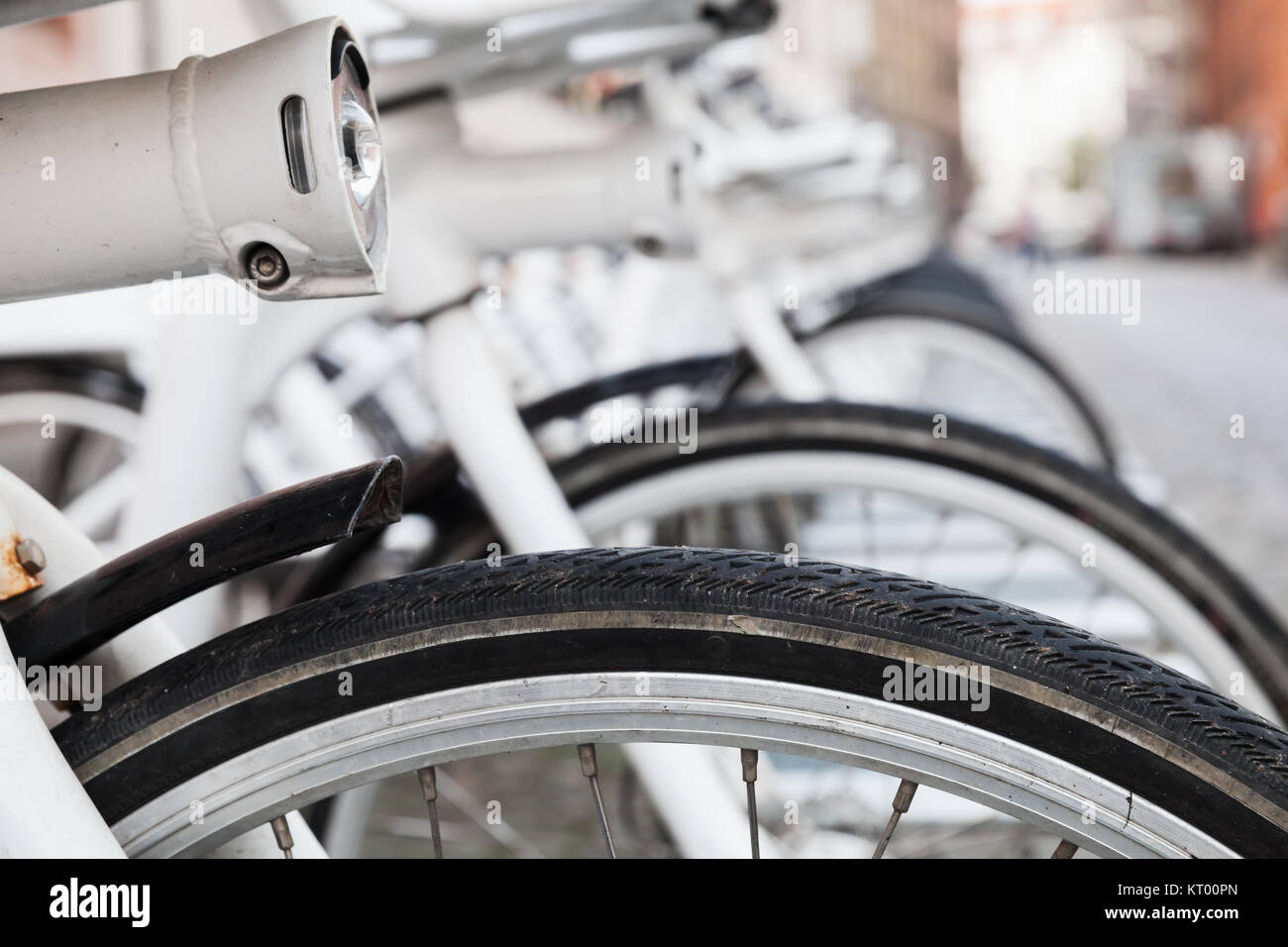 Des vélos à louer blanc stand dans une rangée sur une rue de Copenhague, Danemark Banque D'Images