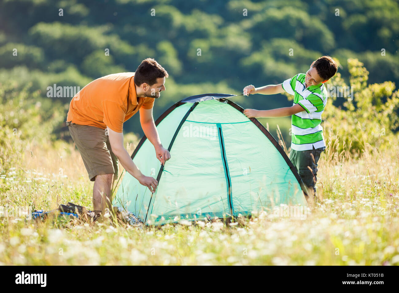 Père et fils sont la mise en place de leur tente dans la nature. Banque D'Images