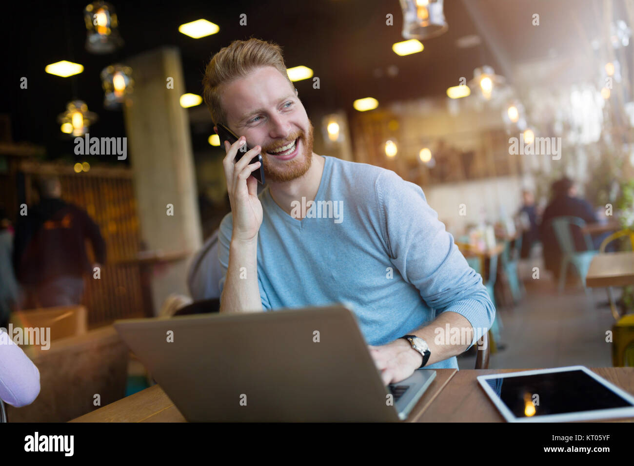 Jeune homme ayant appel in coffee shop Banque D'Images