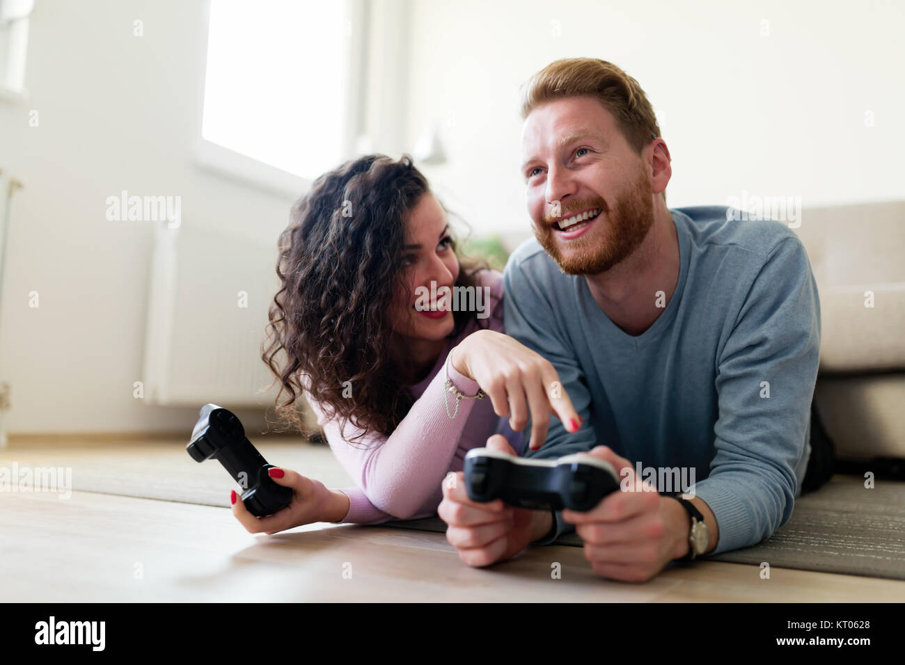 Couple heureux à jouer à des jeux vidéo à la maison Banque D'Images