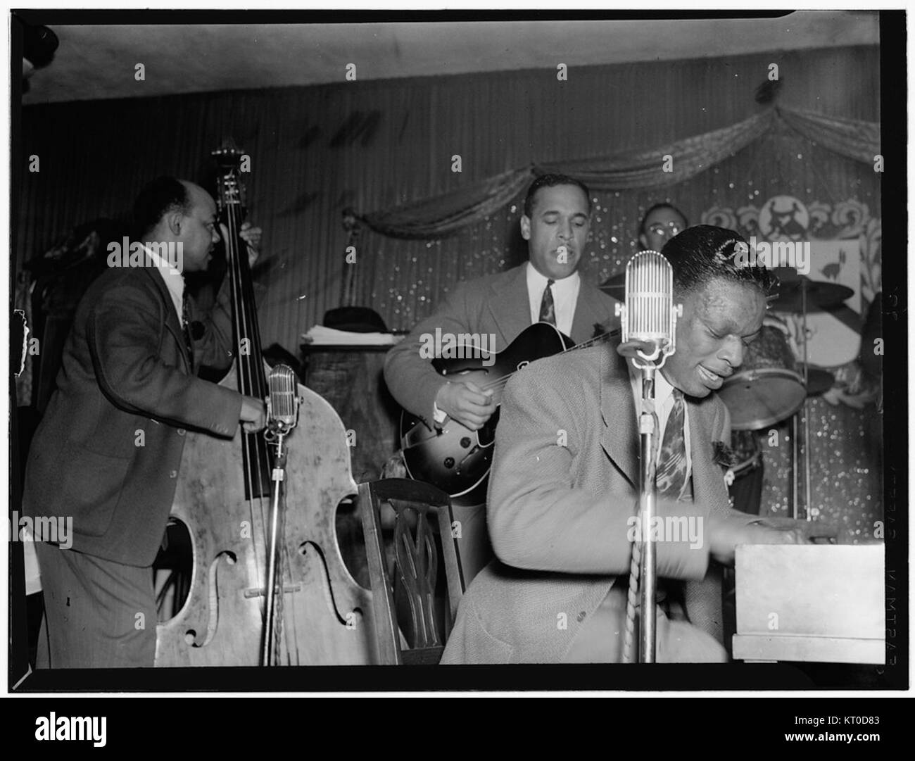 Portrait des musiciens de jazz Wesley Prince, Oscar Moore et Nat King Cole, capturé à Zanzibar, New York, vers juillet 1946. L'image reflète un moment clé de l'histoire du jazz au milieu du XXe siècle, mettant en valeur ces musiciens influents au sommet de leur carrière. Banque D'Images