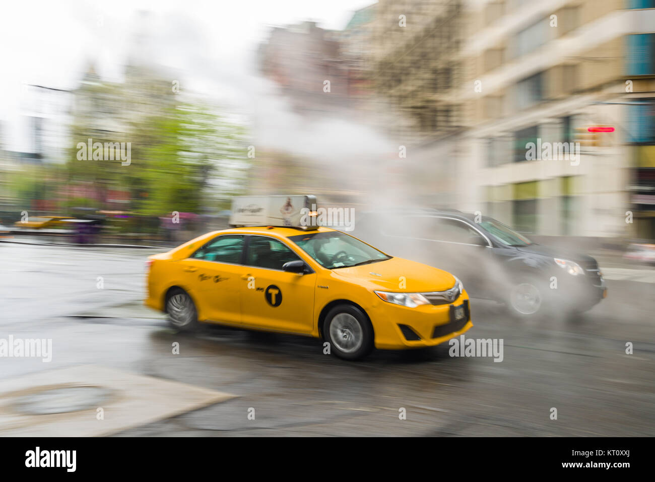 Un panoramique d'un taxi jaune roulant le long d'une rue dans le lower Manhattan, New York, USA Banque D'Images
