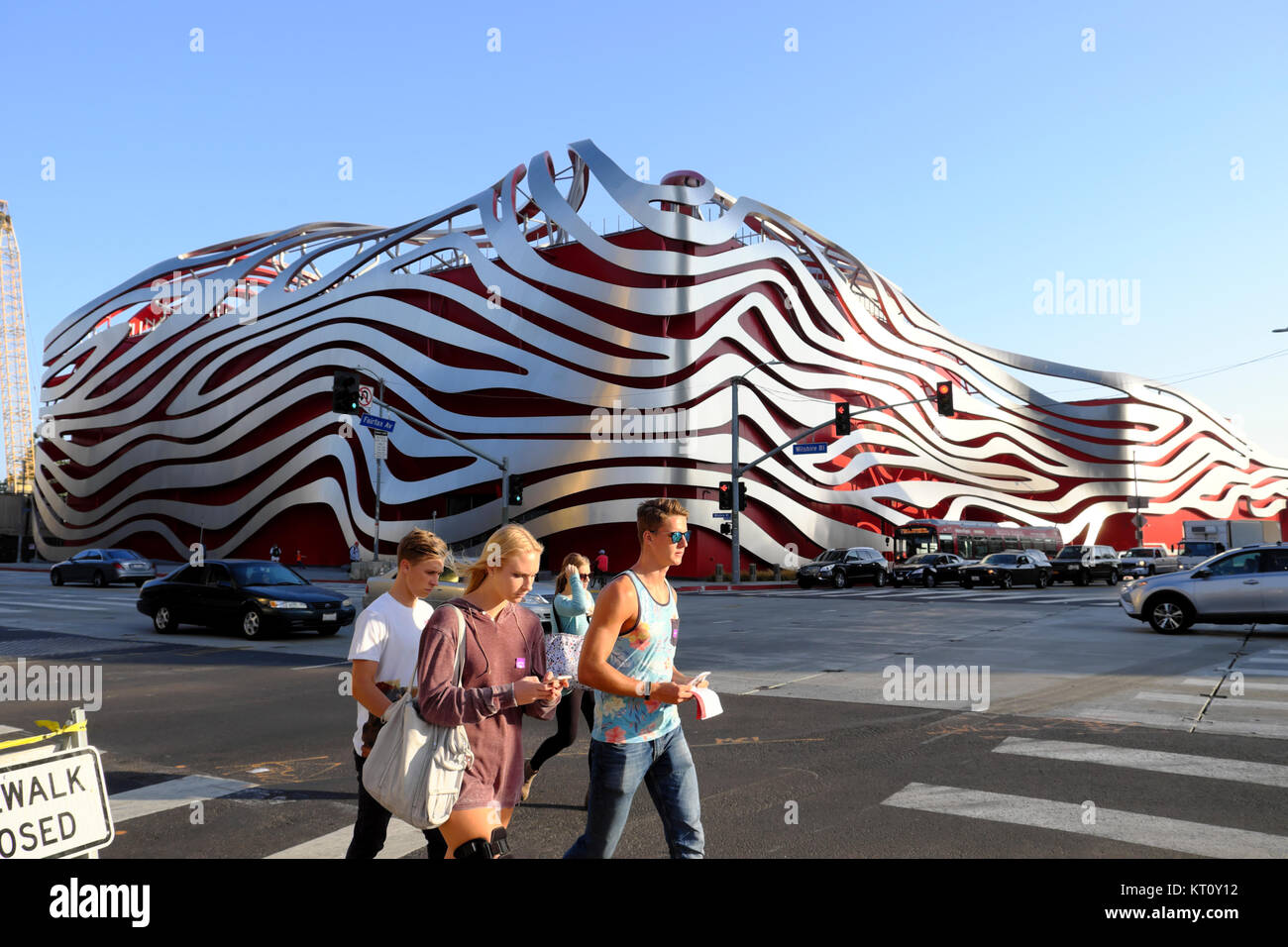 Groupe de jeunes touristes adolescente marchant le long de Wilshire Blvd. passé Petersen Automotive Museum building à Los Angeles, California USA KATHY DEWITT Banque D'Images