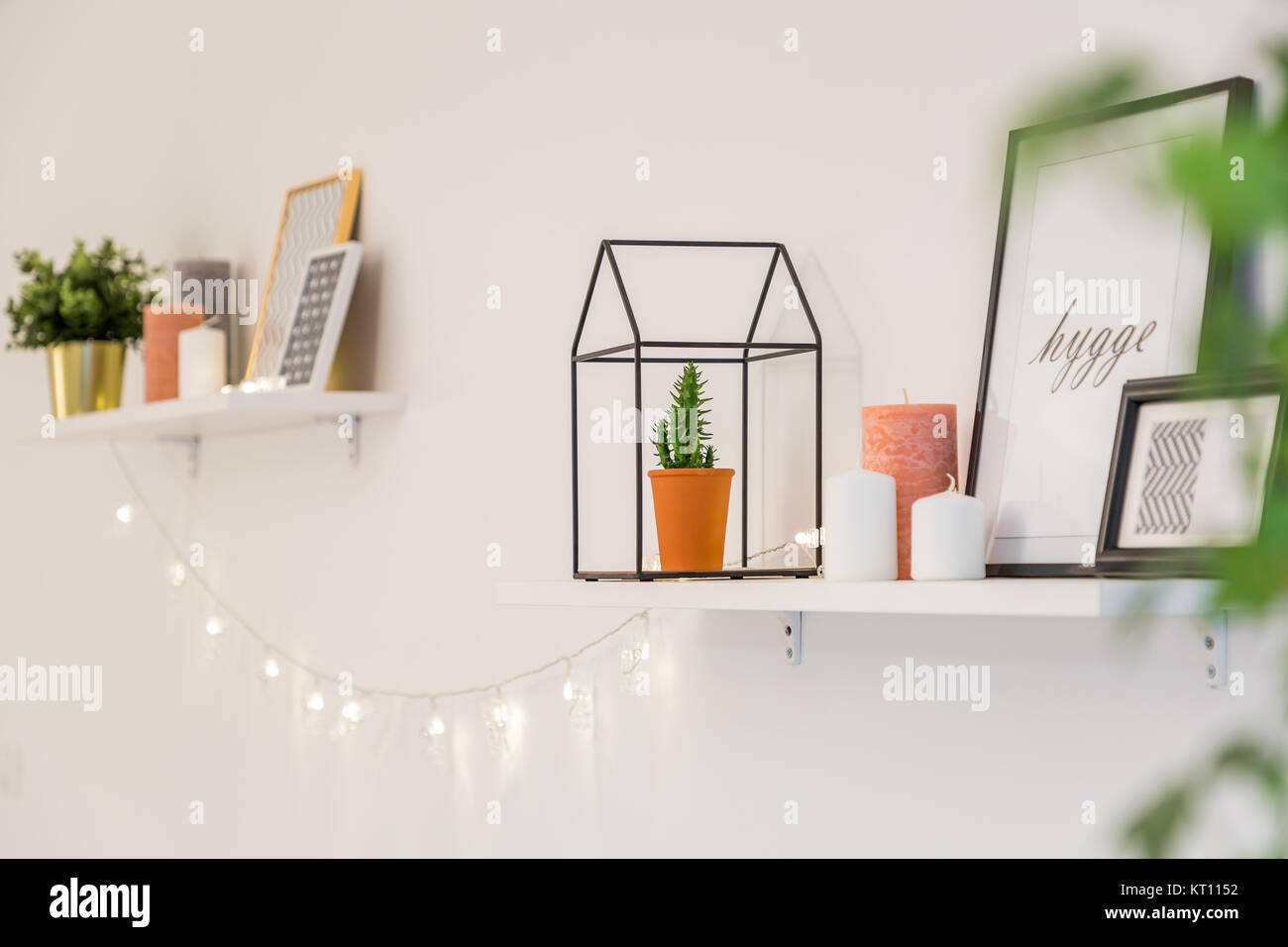 Étagères avec frames, plantes, lumières et autres décorations dans un style scandinave Banque D'Images