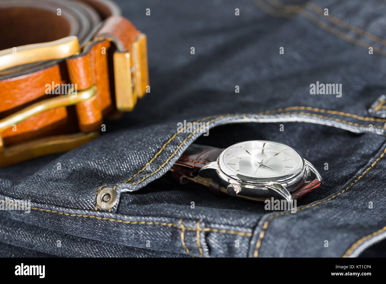 Montre-bracelet et ceinture en cuir sur un jean Banque D'Images
