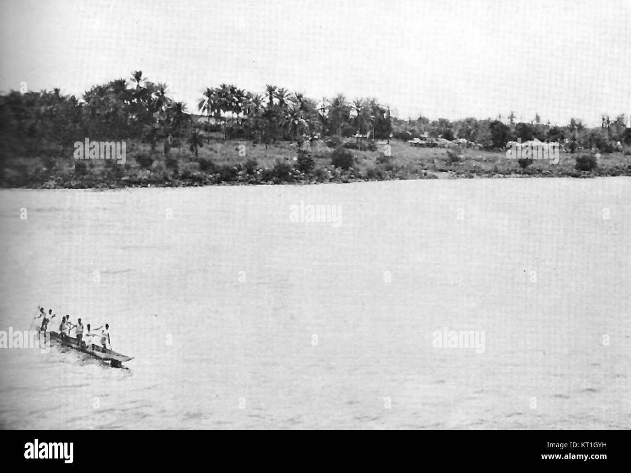 Un canoë traverse le fleuve Congo dans l'ancien Congo belge, reflétant les modes de transport traditionnels de la région. Cette image représente l'importance culturelle et historique de la rivière dans la vie locale et les voyages. Banque D'Images