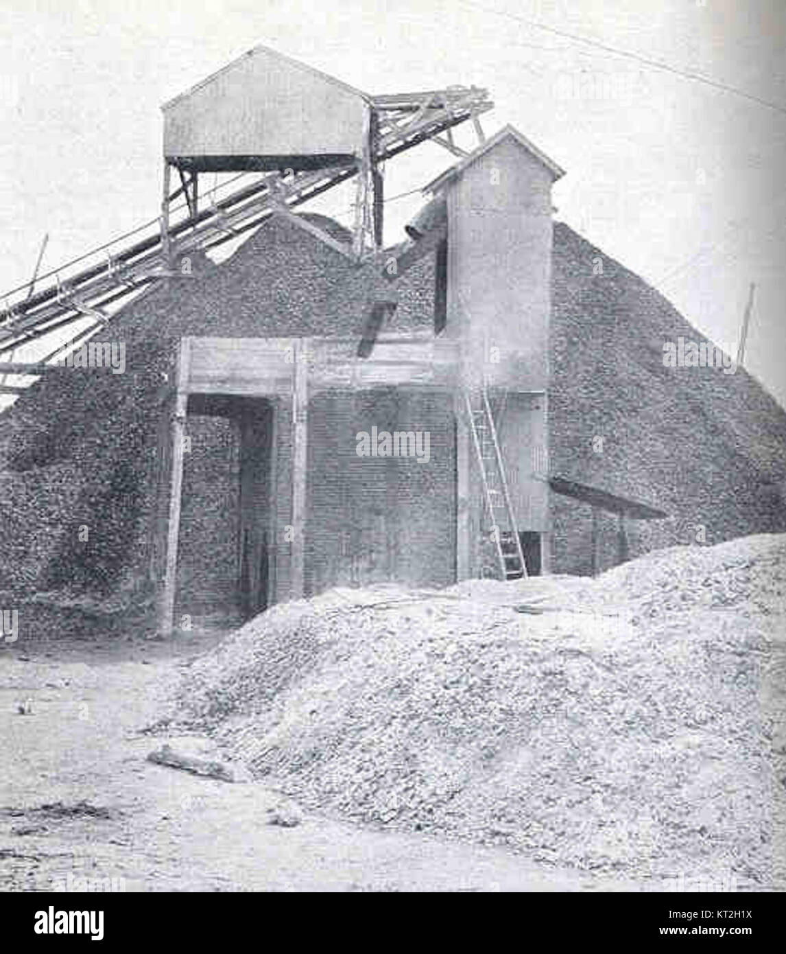Cette image montre un four utilisé pour brûler les coquilles d'huîtres pour produire de la chaux, avec un tas de coquilles en arrière-plan et une pile de chaux au premier plan, illustrant un processus industriel traditionnel de production de chaux. Banque D'Images