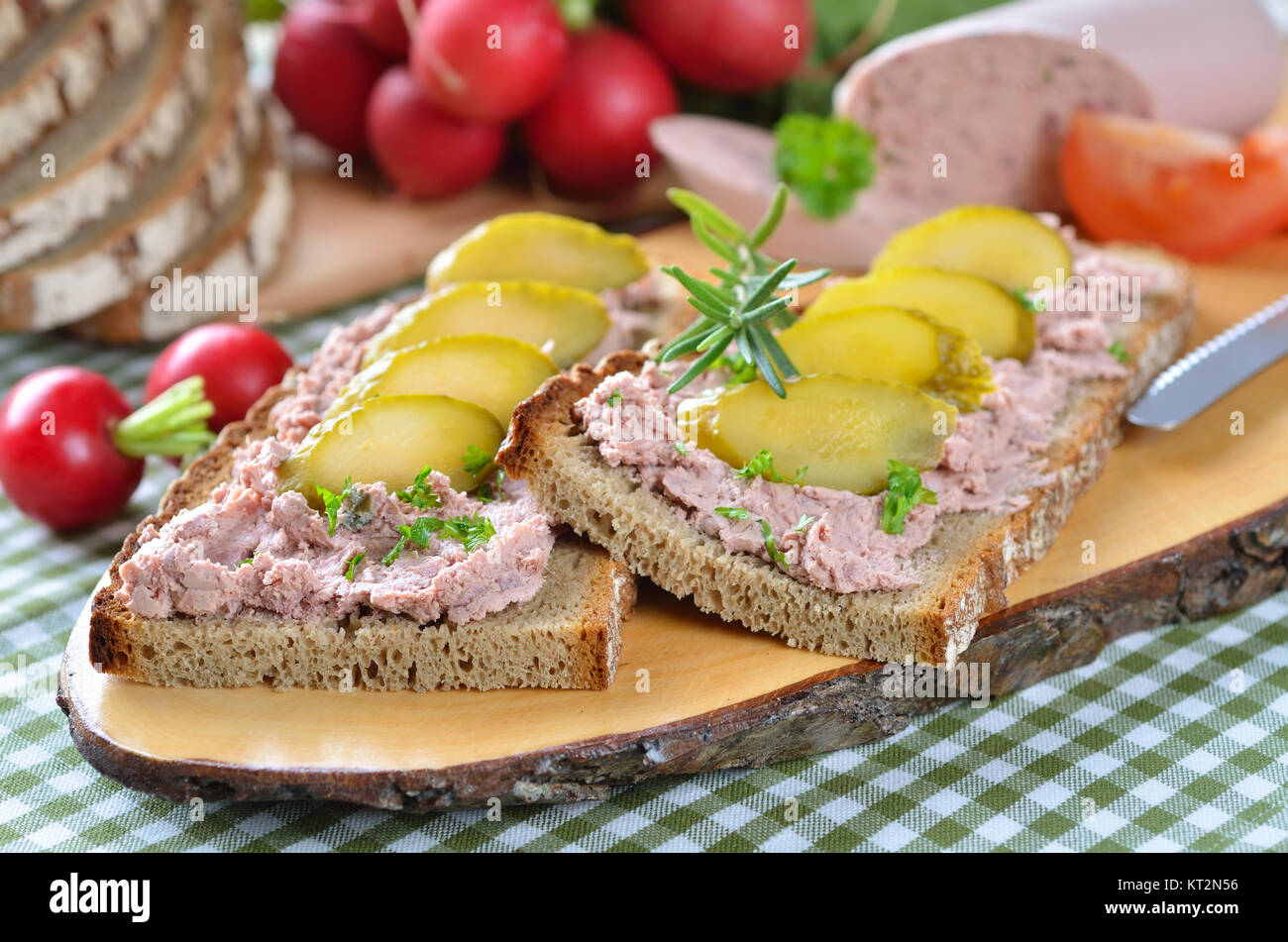 Pain de campagne avec saucisson sur une tranche de bois rustique Banque D'Images