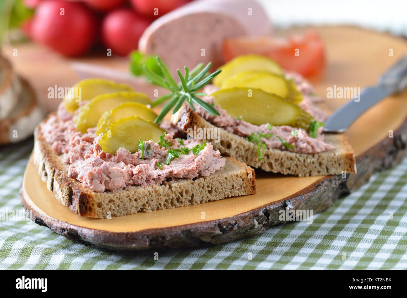 Pain de campagne avec saucisson sur une tranche de bois rustique Banque D'Images