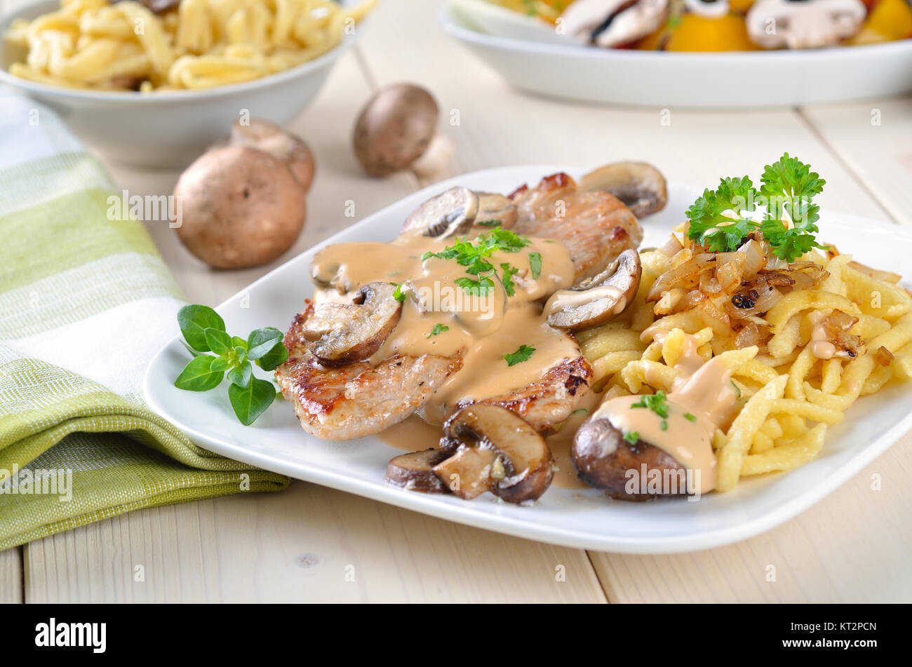 Escalope de porc aux champignons, sauce et spaetzle servi sur une plaque  blanche sur fond blanc Photo Stock - Alamy