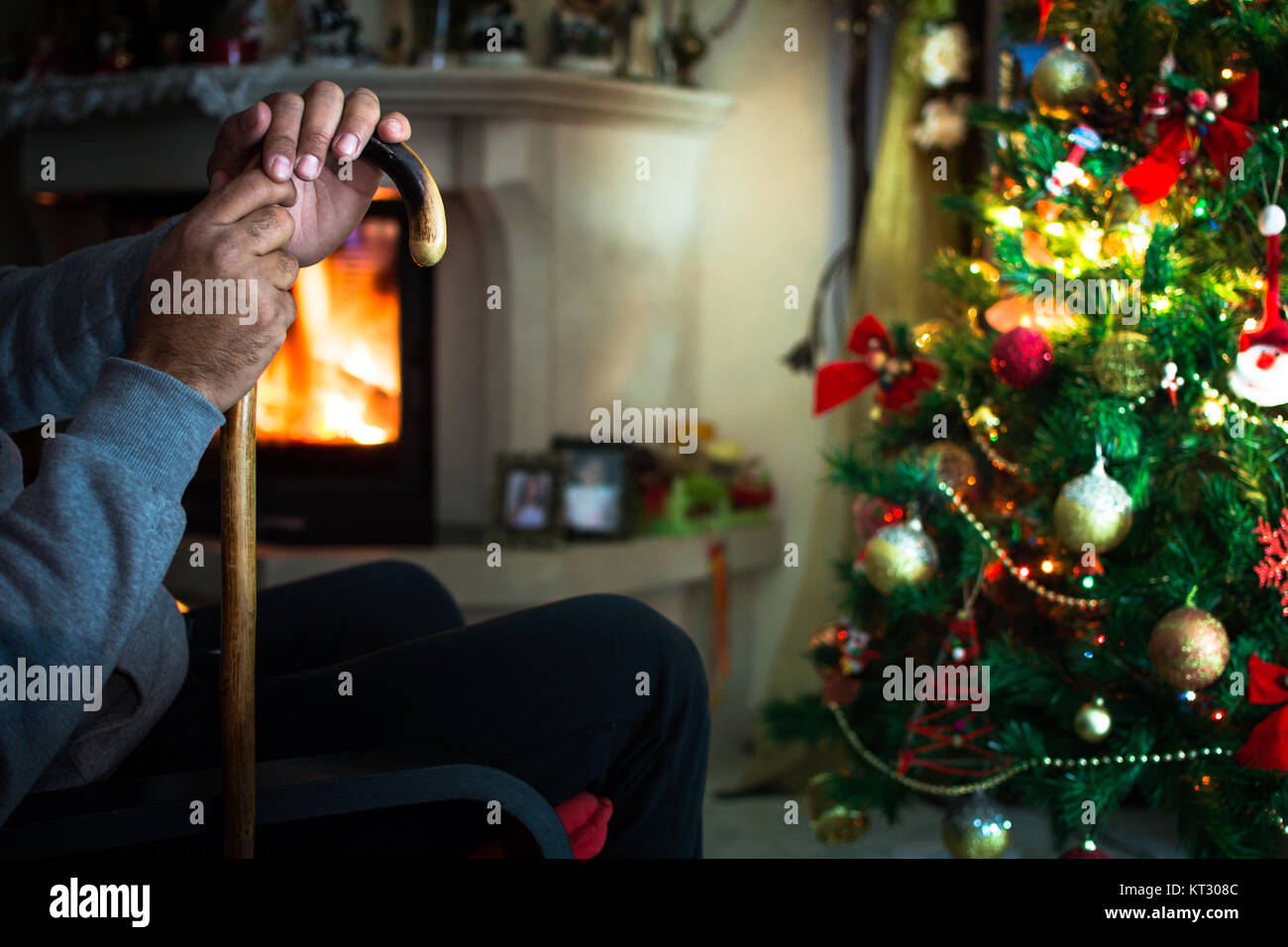 Homme seul la main devant la cheminée avec arbre de Noël. Banque D'Images