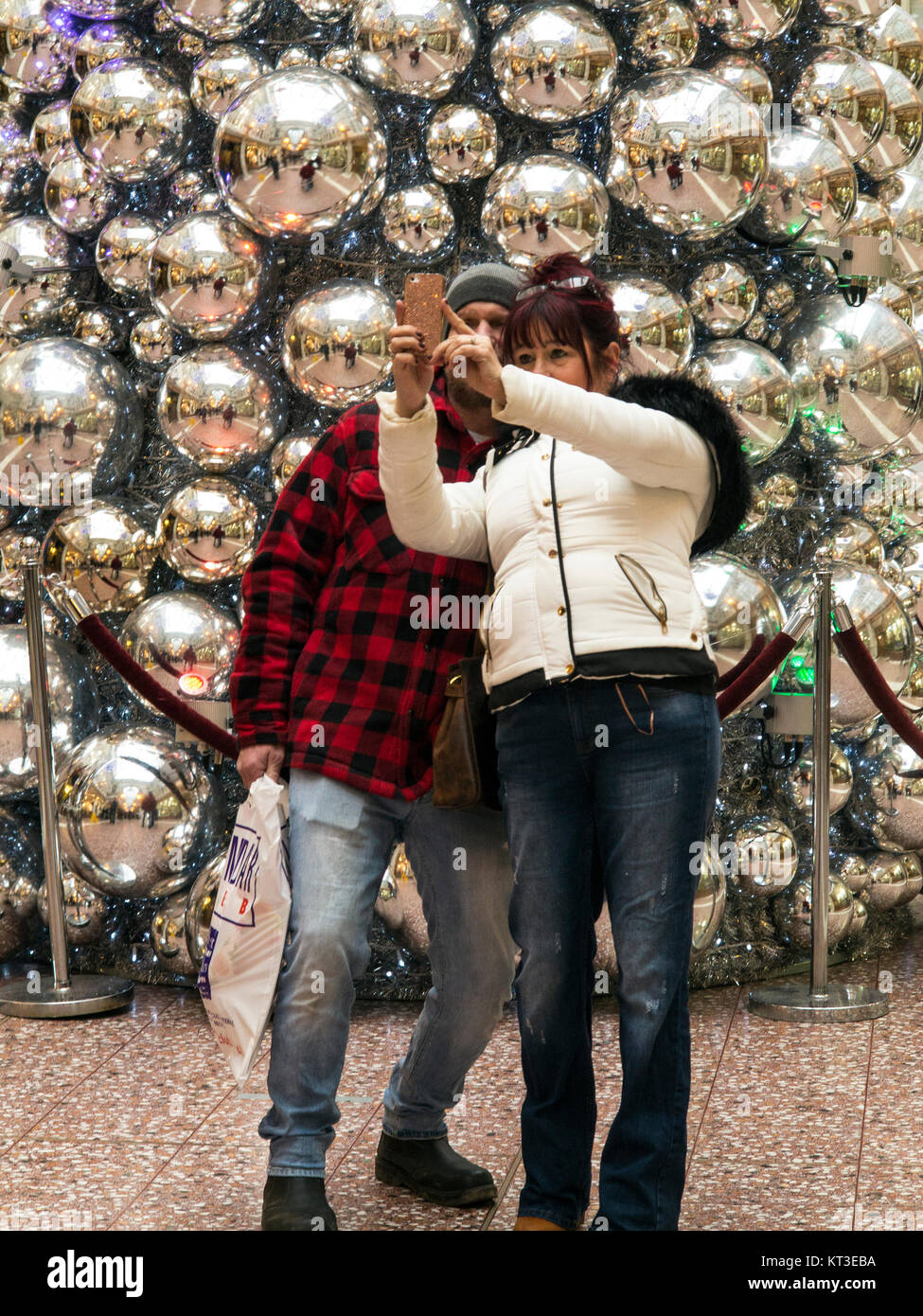 L'homme et de la femme de prendre un en selfies avant de l'arbre de Noël dans le centre commercial Grosvenor Chester Cheshire Angleterre Banque D'Images