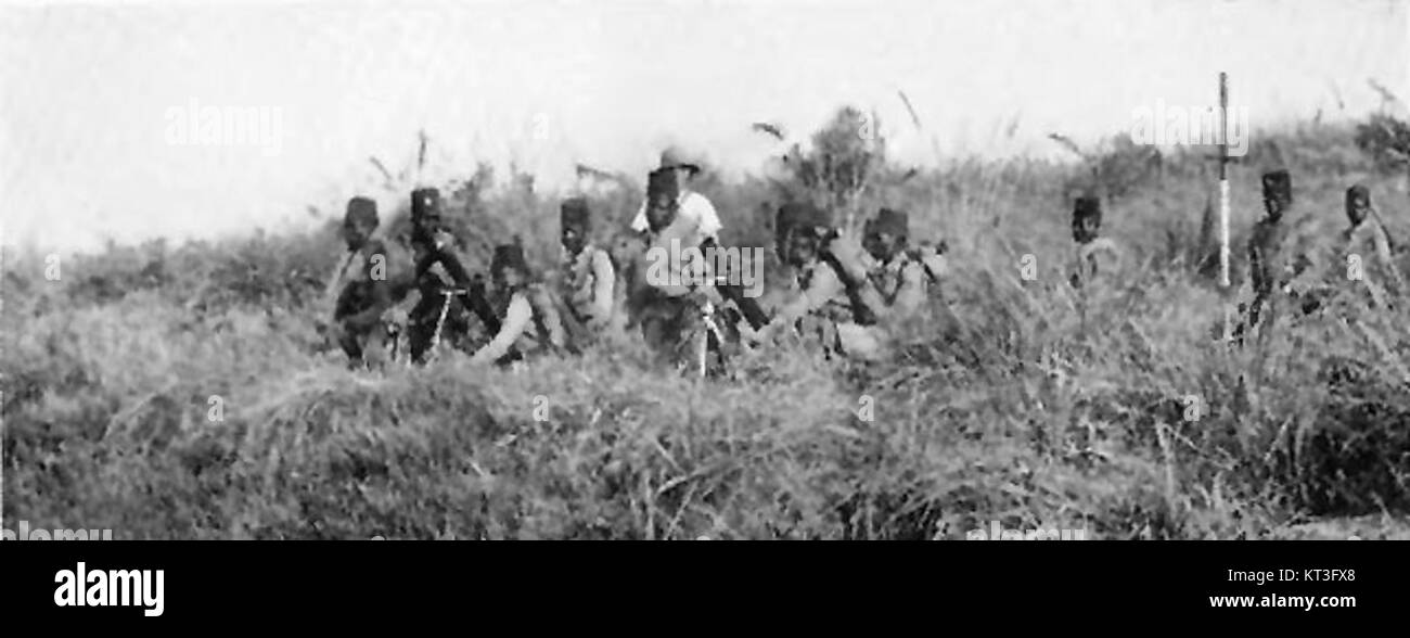 Une image historique représentant la Force publique, une force militaire coloniale au Congo, installant des mitrailleuses au début du XXe siècle, reflétant son rôle dans les efforts militaires coloniaux. Banque D'Images