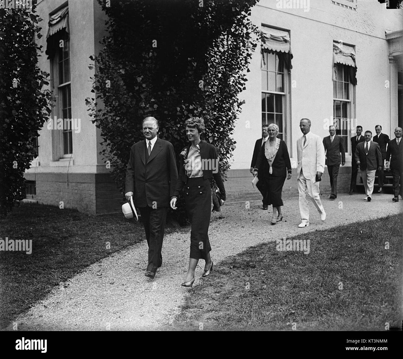 Herbert Hoover, le 31e président des États-Unis, et Amelia Earhart, une aviatrice pionnière, sont vus marcher ensemble. Cette photographie historique capture deux personnages importants de l'histoire américaine. Banque D'Images