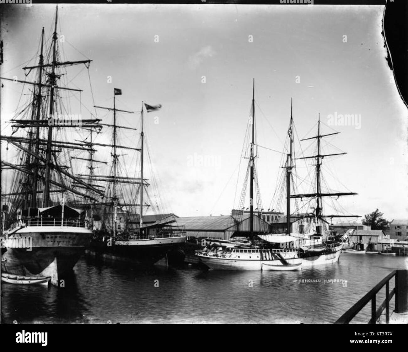 Cette photographie de Brother Bertram capture le port d'Honolulu en 1908, montrant l'activité maritime animée du port et le paysage hawaïen de l'époque. Banque D'Images