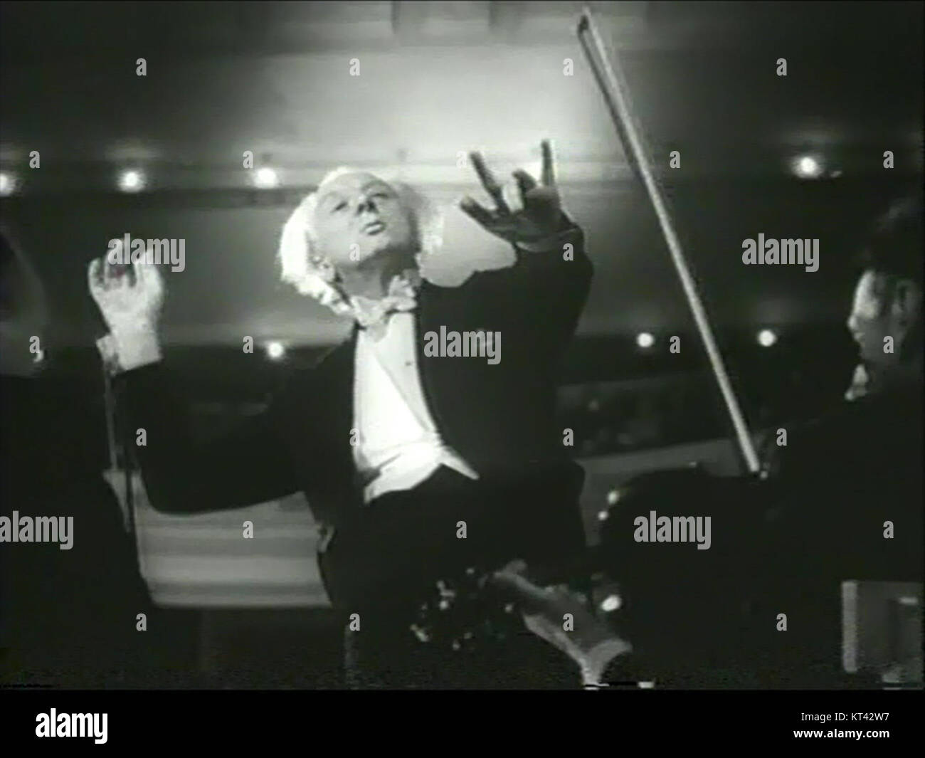 L'image capture Leopold Stokowski dirigeant un orchestre au Carnegie Hall en 1947. Connu pour son travail avec de grands orchestres, la performance de Stokowski dans ce lieu emblématique a marqué un moment important dans l'histoire de la musique classique américaine. Banque D'Images