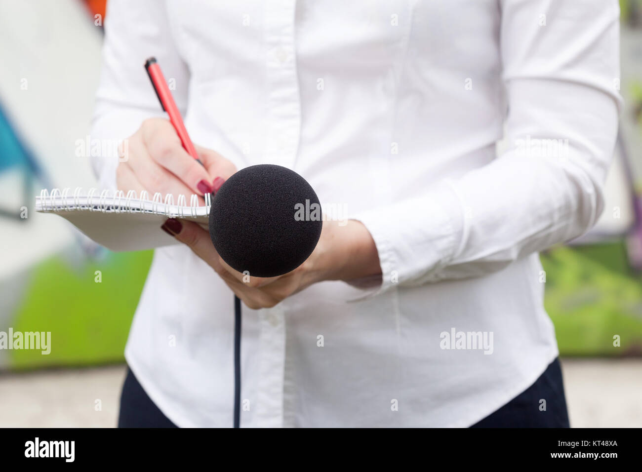 Femme journaliste ou journaliste à la conférence de presse, la rédaction de notes, holding microphone Banque D'Images
