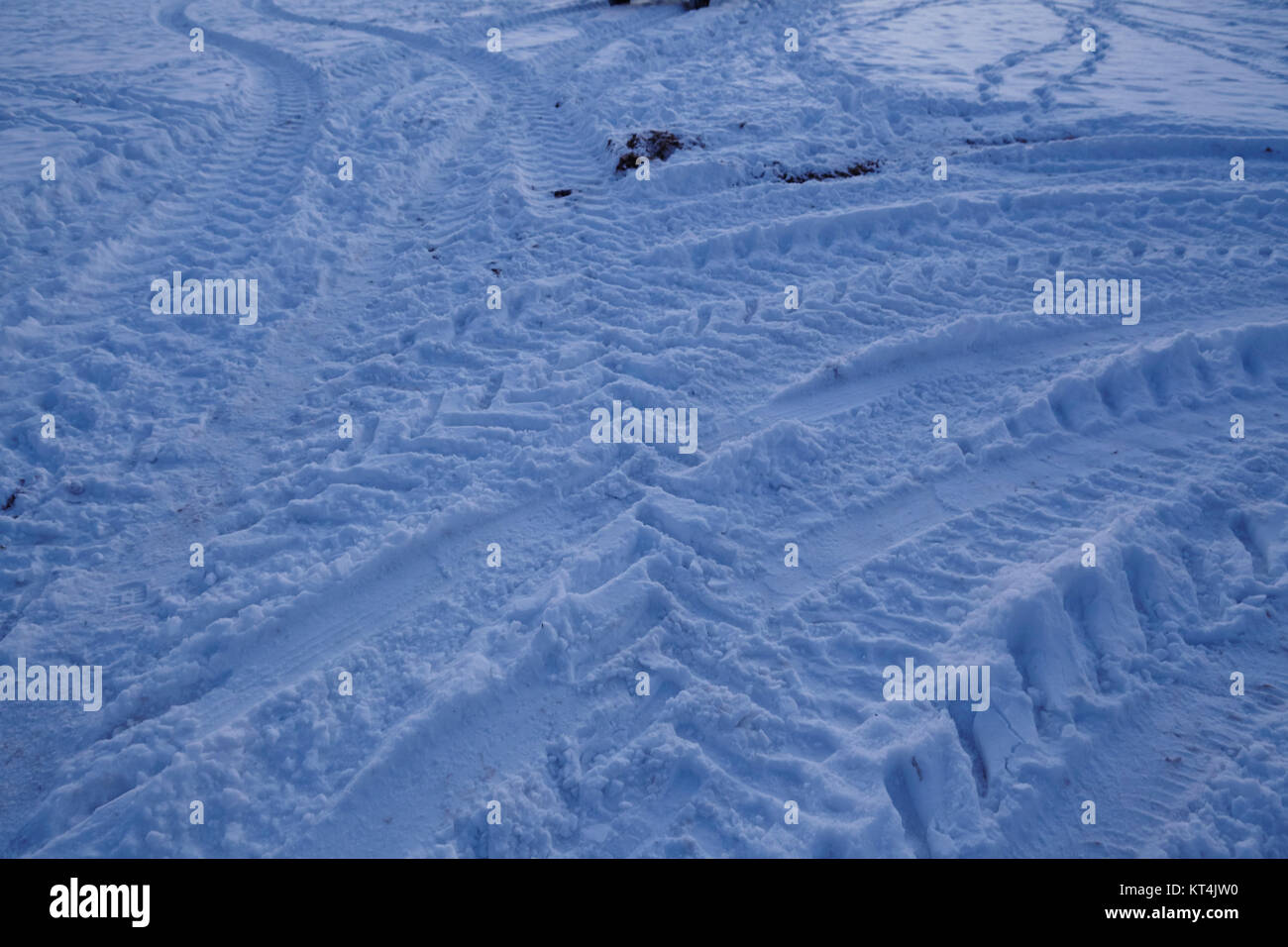 Certaines marques de dérapage conduirait dans un snowscape au point de l'heure bleue en soirée. Banque D'Images