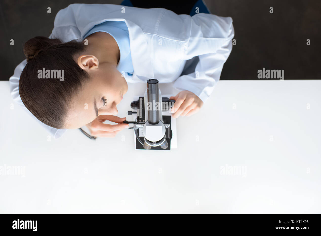 Vue de dessus de scientifique travaillant avec microscope in laboratory Banque D'Images