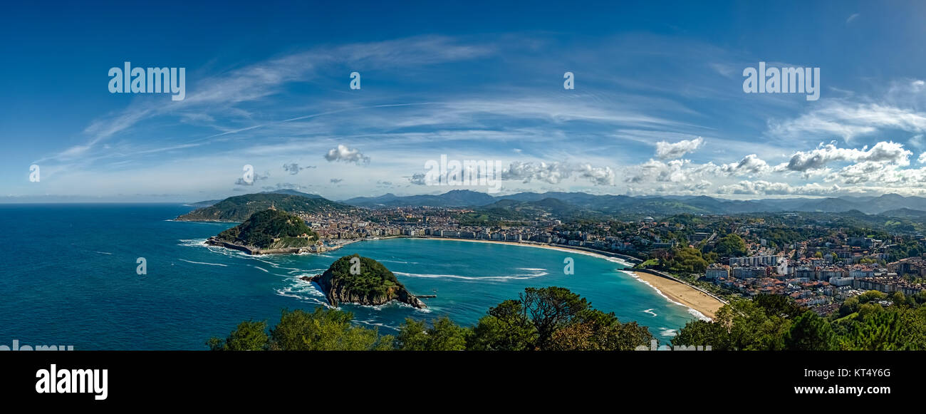 Vue panoramique d'une ville dans une baie magnifique avec des îles et de vertes collines sous un ciel bleu avec quelques nuages blancs Banque D'Images