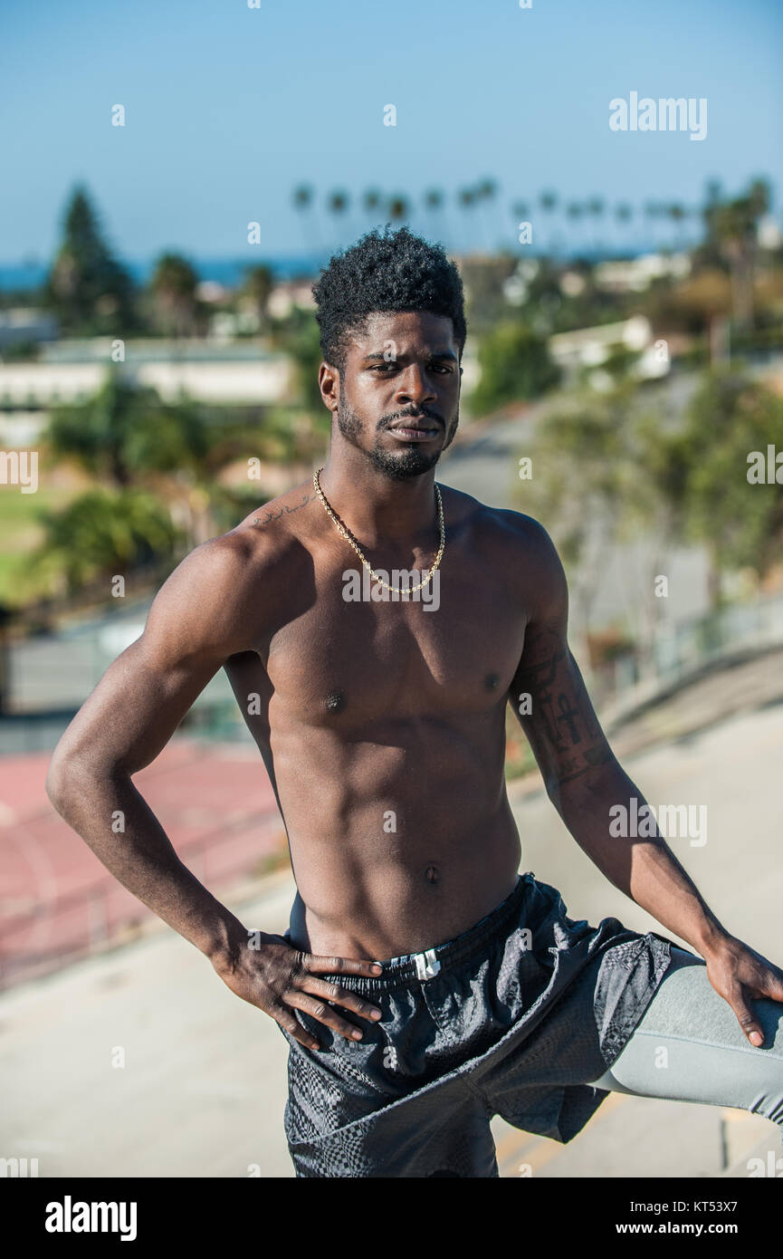 L'athlète jamaïcain musculaire montrant pose assurée avec main posée sur la hanche et regard sérieux. Banque D'Images