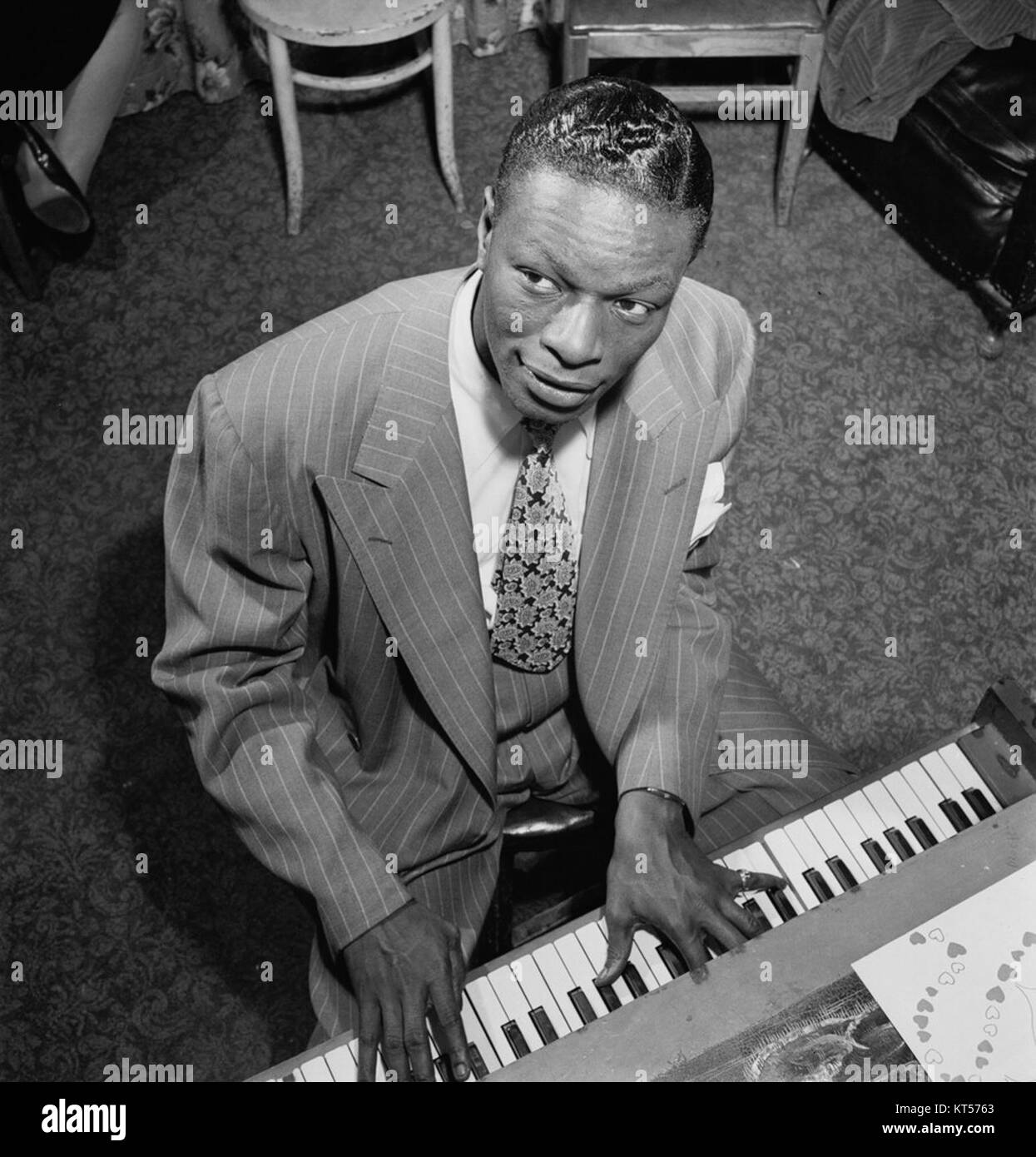 NAT King Cole, chanteur de jazz et pop américain emblématique, figure dans ce portrait. Connu pour sa voix douce et ses talents de piano, il est une figure majeure de la musique américaine du milieu du XXe siècle. Banque D'Images
