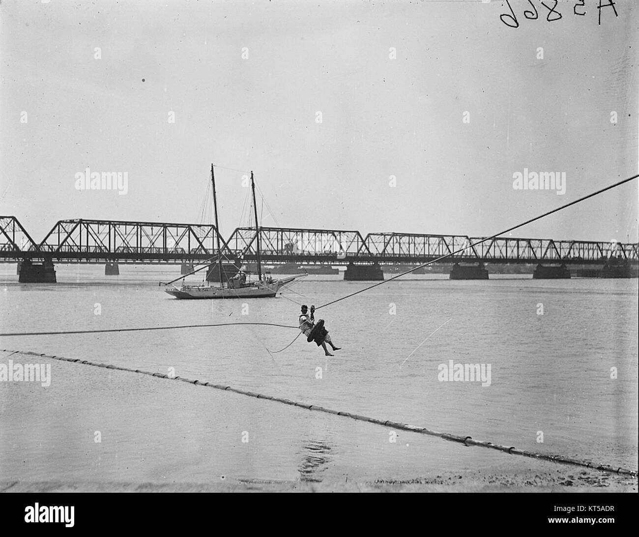 Une personne est vue suspendue au-dessus du fleuve Potomac, probablement engagée dans une activité comme une performance aérienne ou un sauvetage, présentant un moment dramatique d'interaction humaine avec l'environnement. Banque D'Images