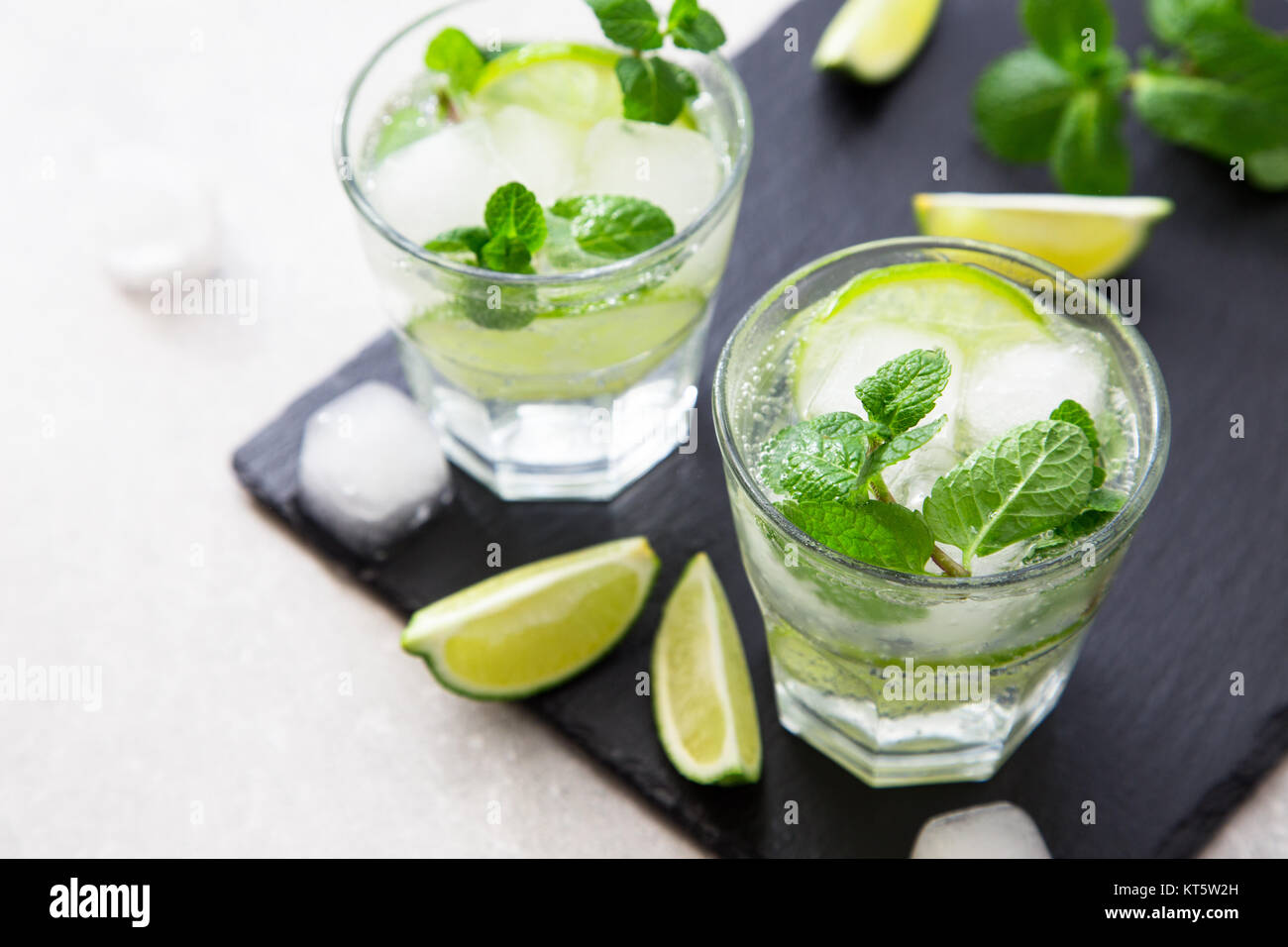 Rempli de limonade d'été mojito dans un verre sur un fond noir en ardoise et du conseil. Banque D'Images