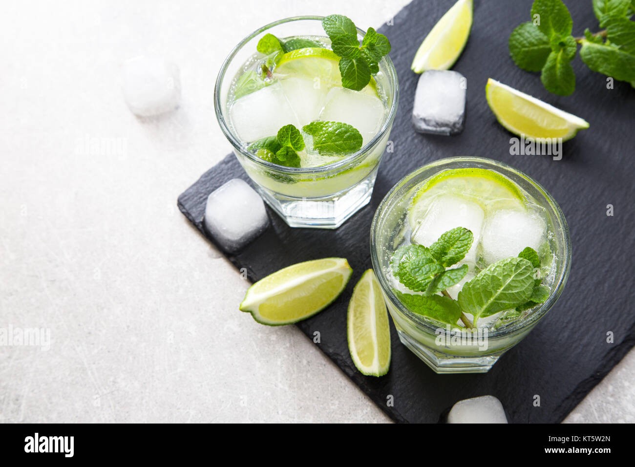 Rempli de limonade d'été mojito dans un verre sur un fond noir en ardoise et du conseil. Banque D'Images