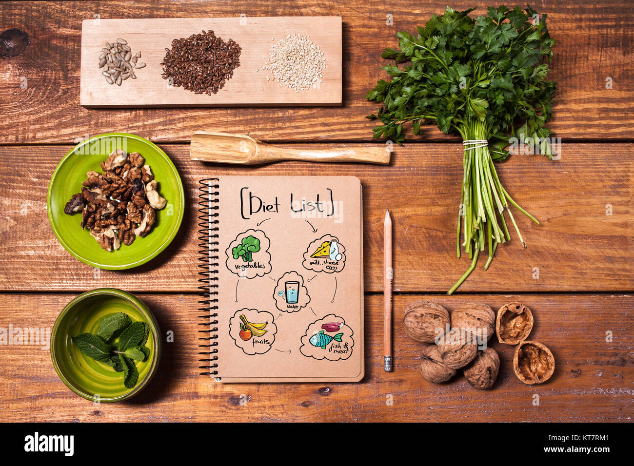 Ordinateur portable pour les recettes, les noix, le persil et les graines sur la table en bois. Banque D'Images Ordinateur portable pour les recettes, les noix, le persil et les graines sur la table en bois. Banque D'Images