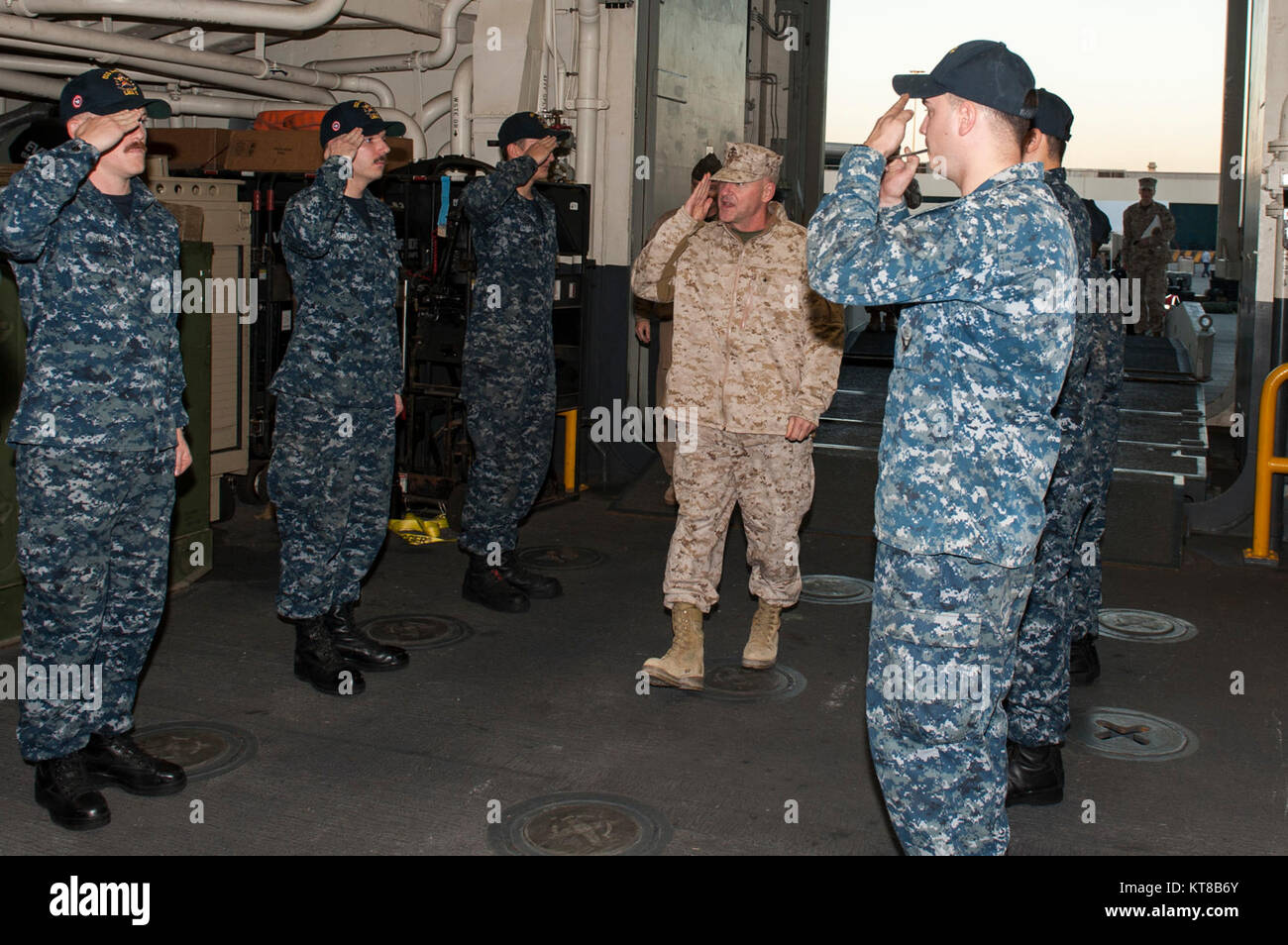 Marine Corps Brig. Le général Robert Sofge, Directeur, Centre des opérations interarmées - Bagdad et Commandant général adjoint - Opérations, Force interarmées du Commandement de la composante terrestre (CJFLCC), Commandant, Groupes de forces interarmées multinationales (GFIM), est salué par les garçons face à son arrivée à l'assaut amphibie USS America (LHA 6) au cours de l'horaire du navire dans le port de Manama, Royaume de Bahreïn. L'Amérique est le navire amiral de l'Amérique du groupe amphibie et, avec l'entrepris 15e Marine Expeditionary Unit, est déployé sur le 5e flotte américaine zone d'opérations à l'appui d'opérations de sécurité maritime Banque D'Images