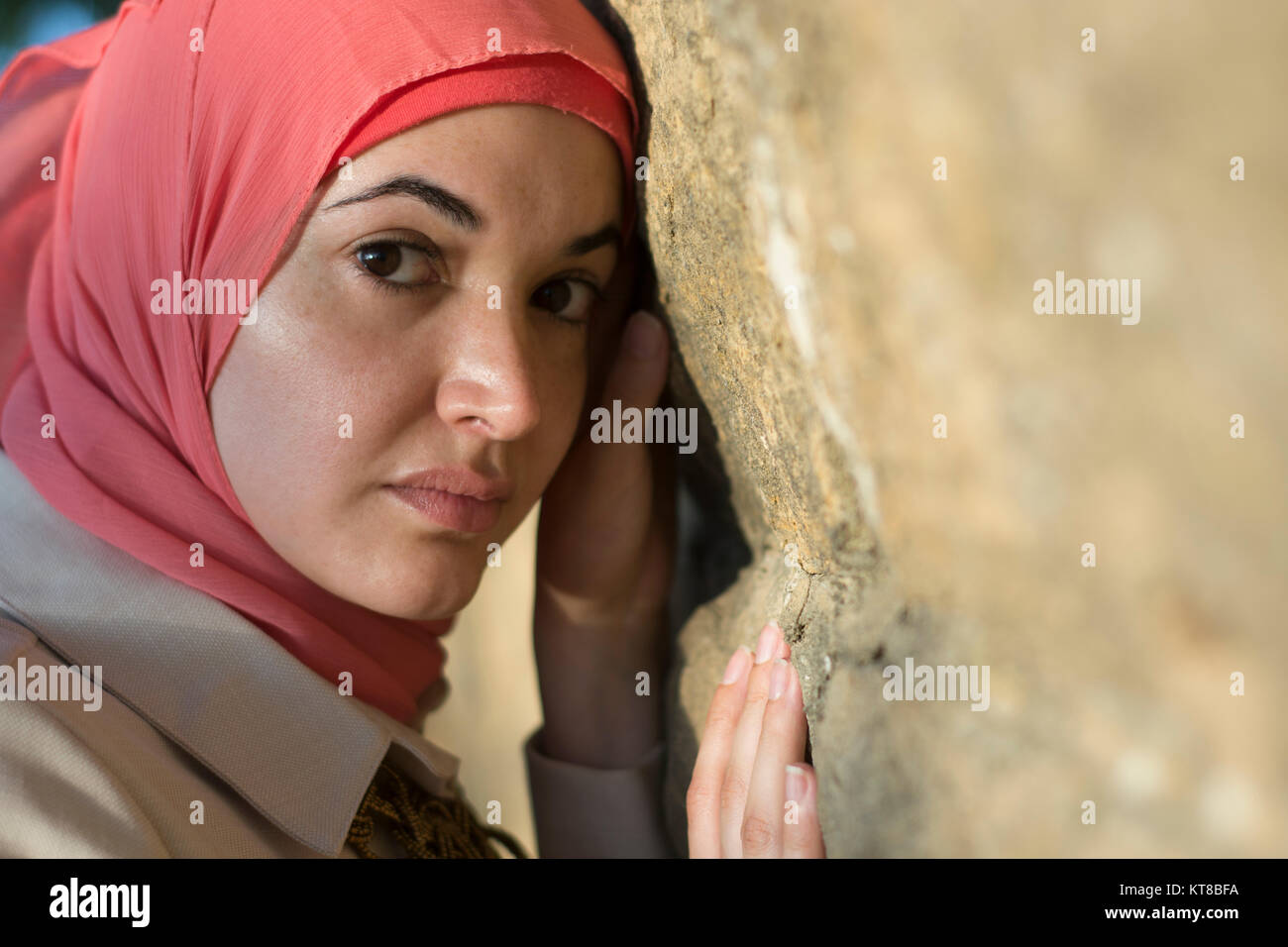 Femme musulmane sérieuse appuyé contre un mur à l'extérieur Banque D'Images