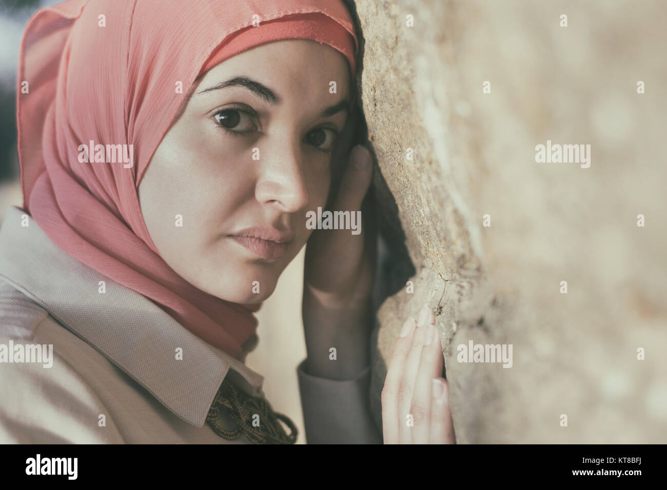 Femme musulmane sérieuse appuyé contre un mur à l'extérieur Banque D'Images