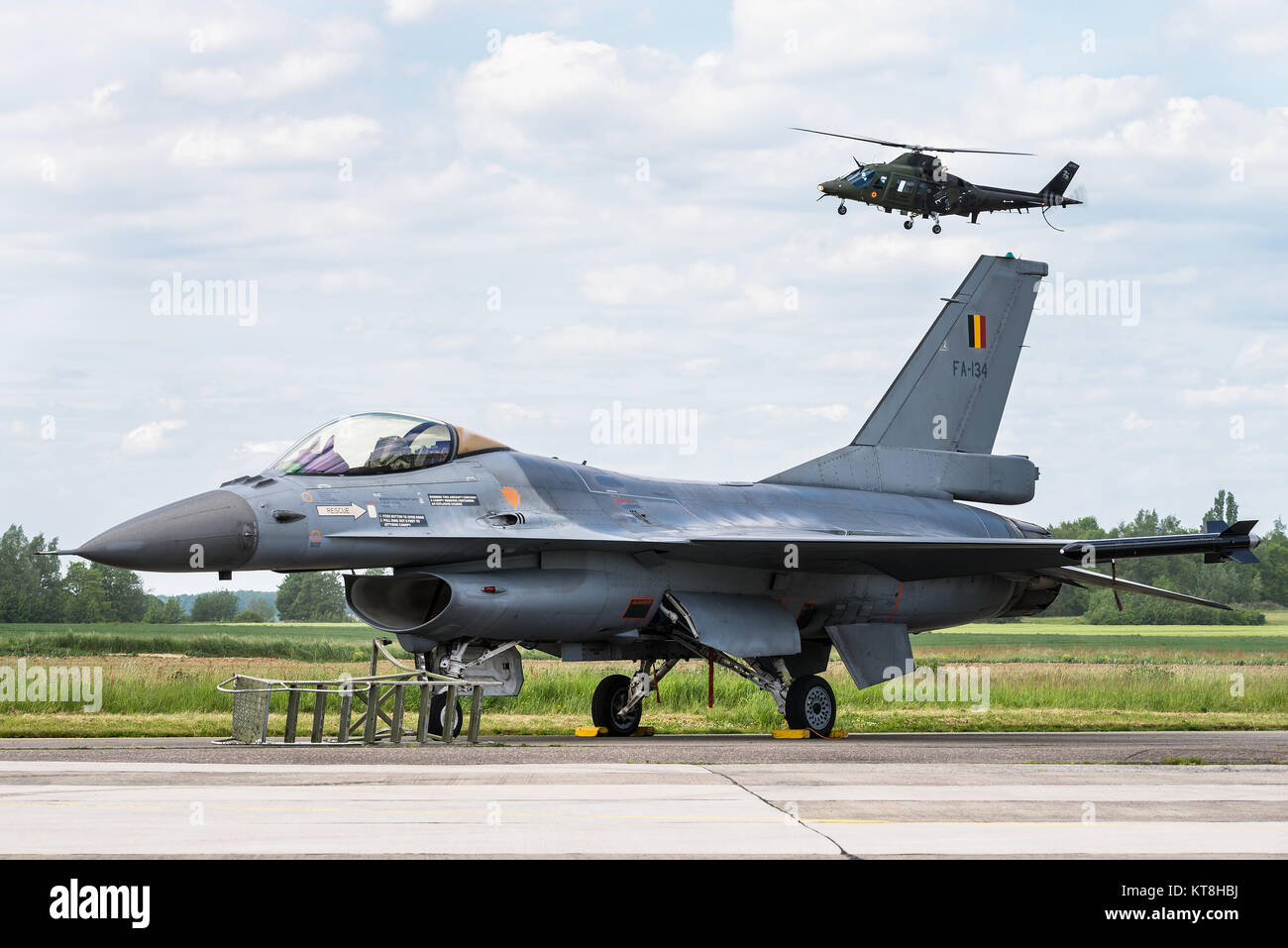 Un avion de chasse F-16 et un hélicoptère Agusta A109 de la Force Aérienne belge à la base aérienne de Beauvechain en Belgique. Banque D'Images