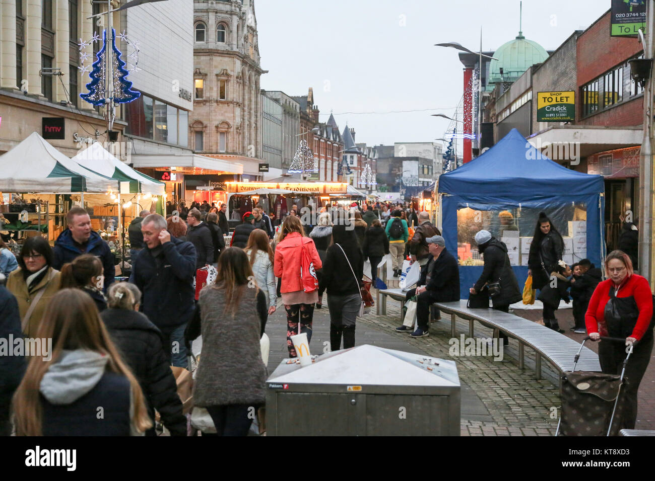 Southend on Sea, Royaume-Uni. 22 décembre 2017. Un marché piétonnier animé illuminé par des lumières festives, avec des gens faisant du shopping, socialisant et se relaxant sur des bancs. La scène présente des étals blancs et bleus à verrière, une architecture historique et des décorations saisonnières, capturant le dynamisme de la vie communautaire dans une ville ou une ville britannique. Avec de nombreux employés payés tôt avant les vacances de Noël, Southend High Street bénéficie d'un début de semaine chargé pour le week-end avant Noël. Crédit : Penelope Barritt/Alamy Live News Banque D'Images