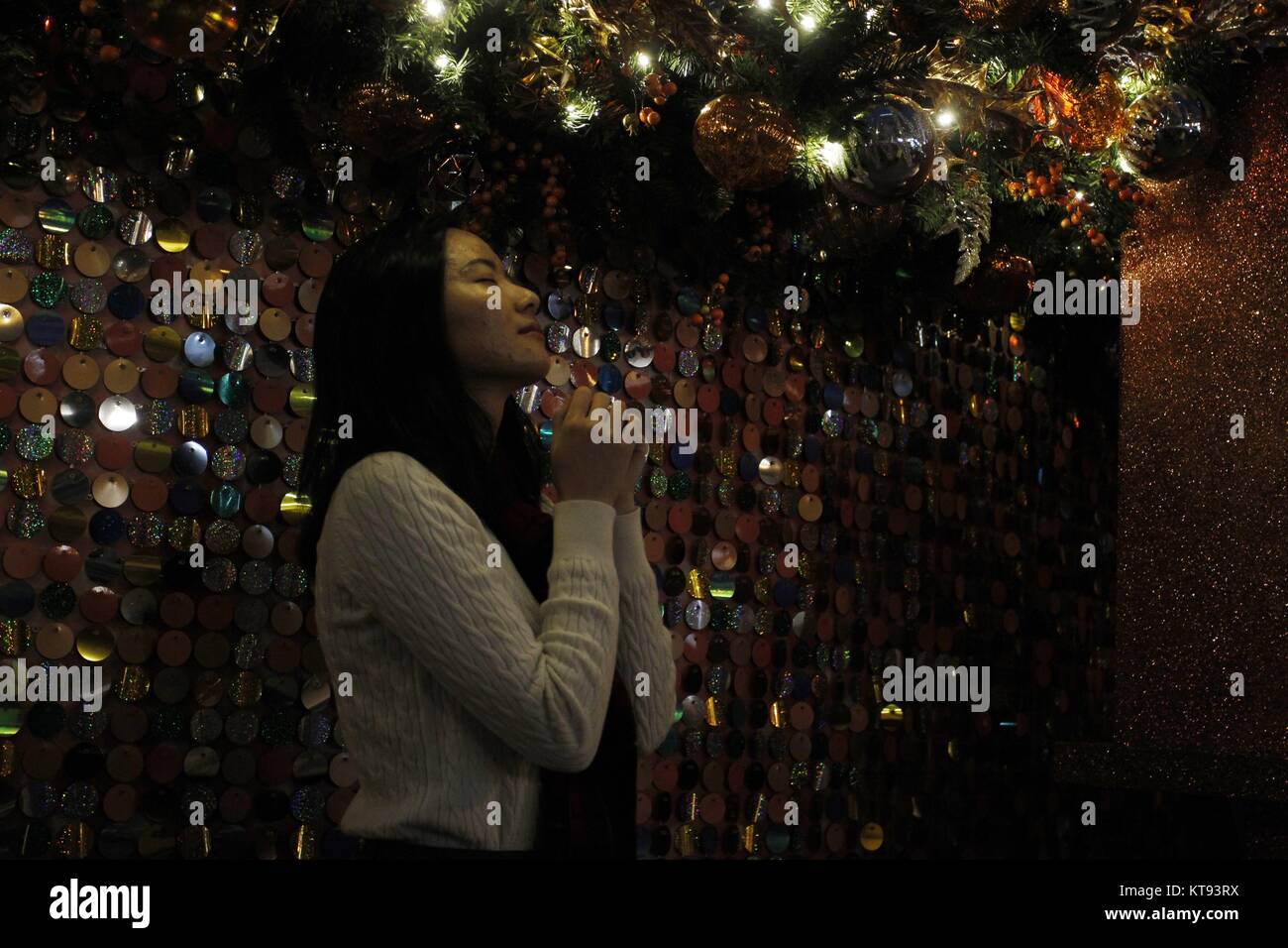 Hong Kong, Chine. 26Th Dec 2017. Jeune femme grève une prière posent pour l'appareil photo d'amis sous le grand arbre de Noël dans le centre financier de Central. Les citoyens de Hong Kong sera célébrer Noël demain. 23-déc.2017 Hong Kong.ZUMA/Liau Chung Ren : Crédit Liau Chung Ren/ZUMA/Alamy Fil Live News Banque D'Images