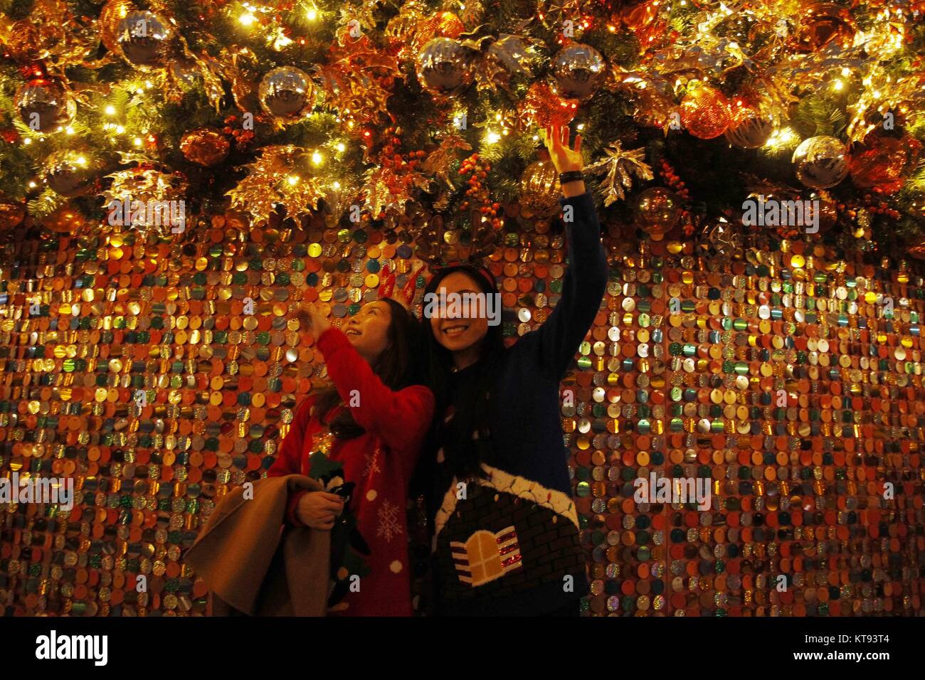 Hong Kong, Chine. 26Th Dec 2017. Les jeunes femmes posent pour l'appareil photo sous un grand arbre de Noël dans le centre financier au niveau central. Les citoyens de Hong Kong sera célébrer Noël demain. 23-déc.2017 Hong Kong.ZUMA/Liau Chung Ren : Crédit Liau Chung Ren/ZUMA/Alamy Fil Live News Banque D'Images